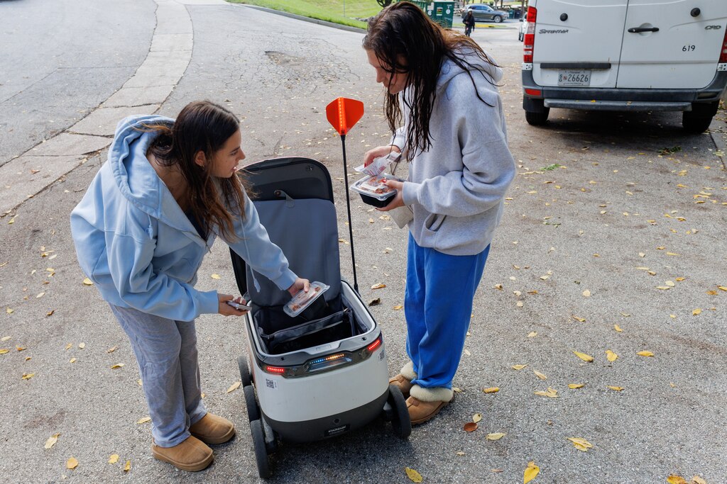 Friday, Oct. 10, 2025 in Towson- GrubHub food delivery robots take food from on-campus eateries to anywhere on the Towson University campus. Freshmen Ali Beane and Mazzi Bouve unpack their order.