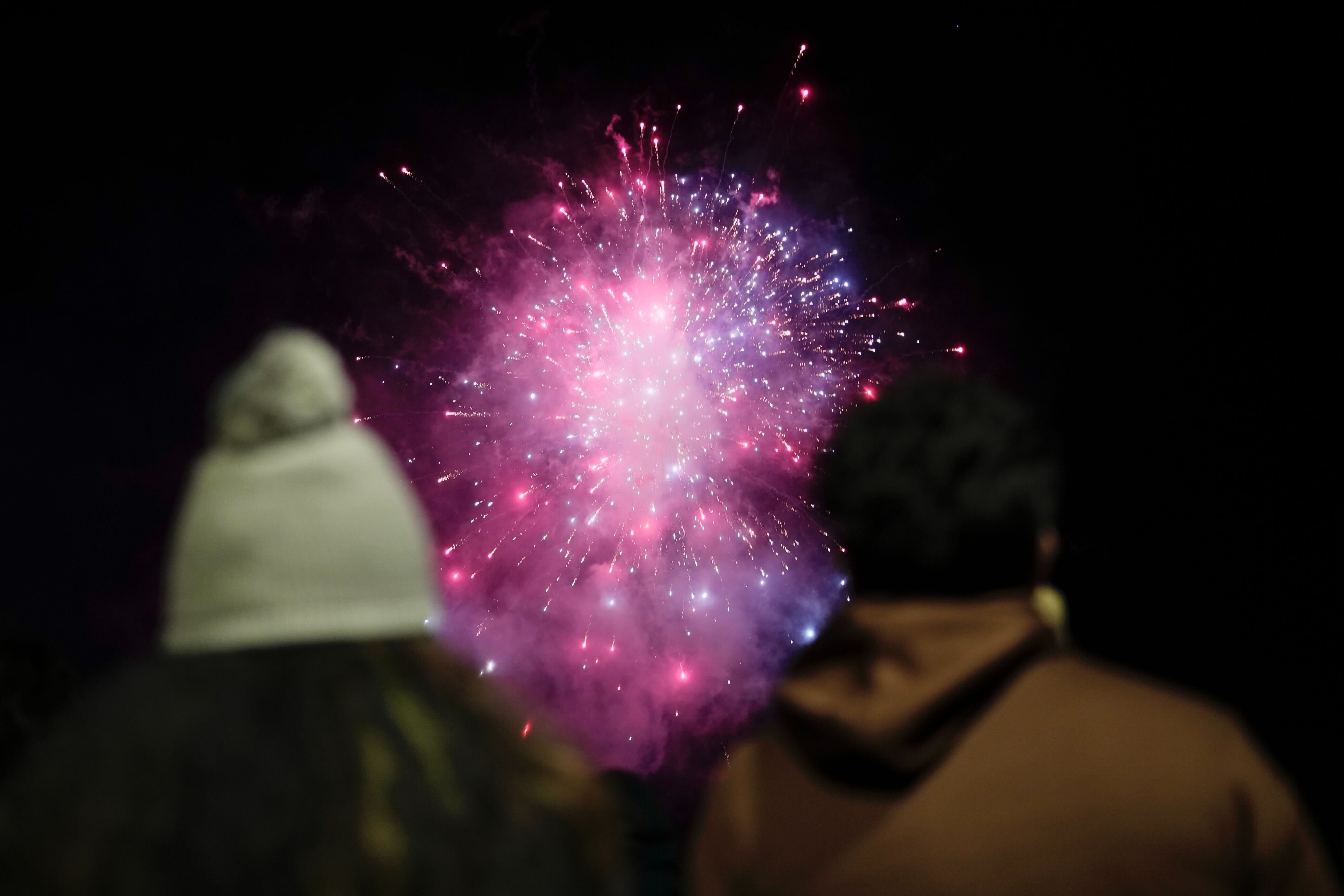People enjoy a fireworks show by the Inner Harbor to ring in the new year in Baltimore on Jan. 1, 2025.
