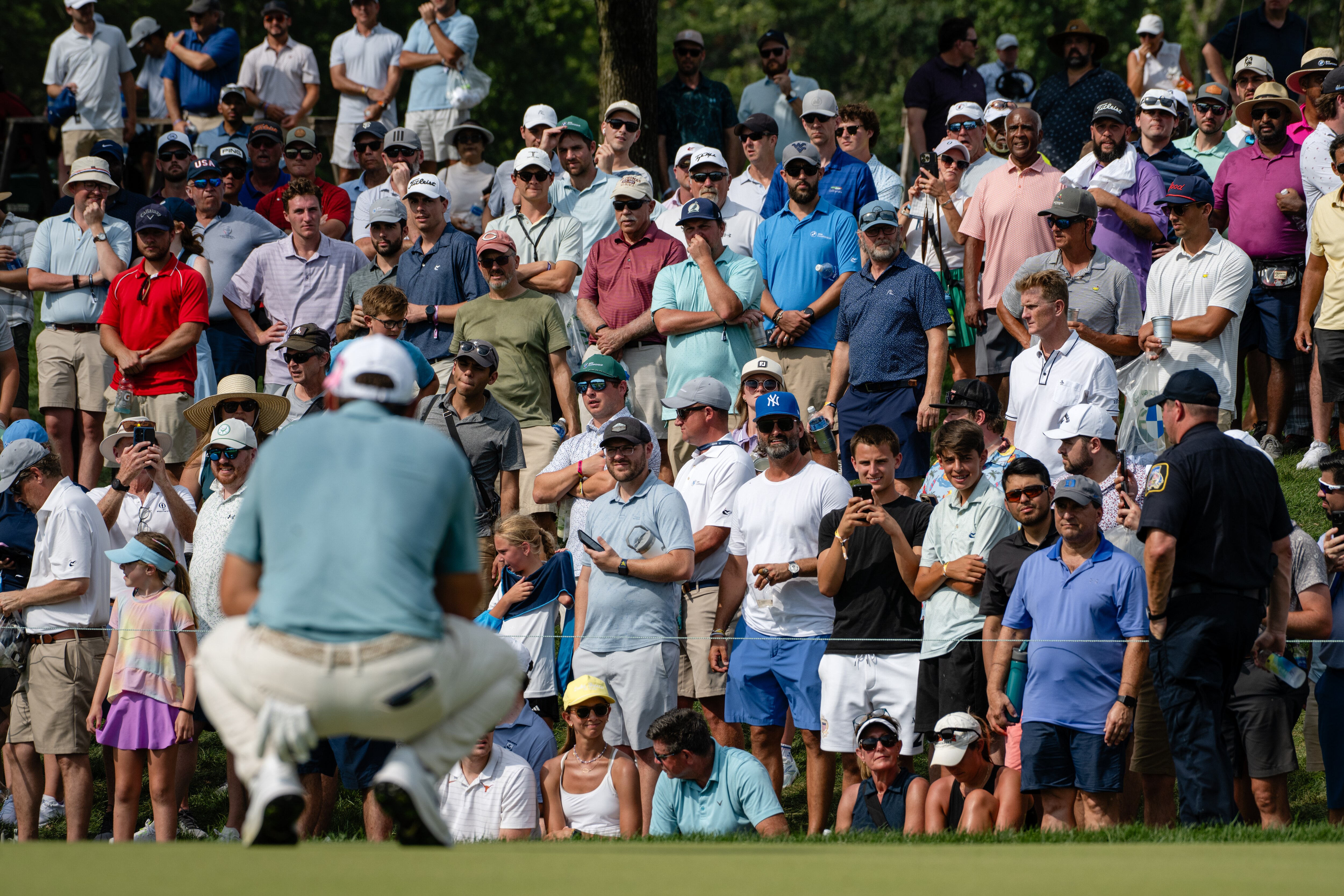 A large gallery watches as Scottie Scheffler lines up a putt on the 12th green Sunday during the final round of the BMW Championship at Caves Valley Golf Club.