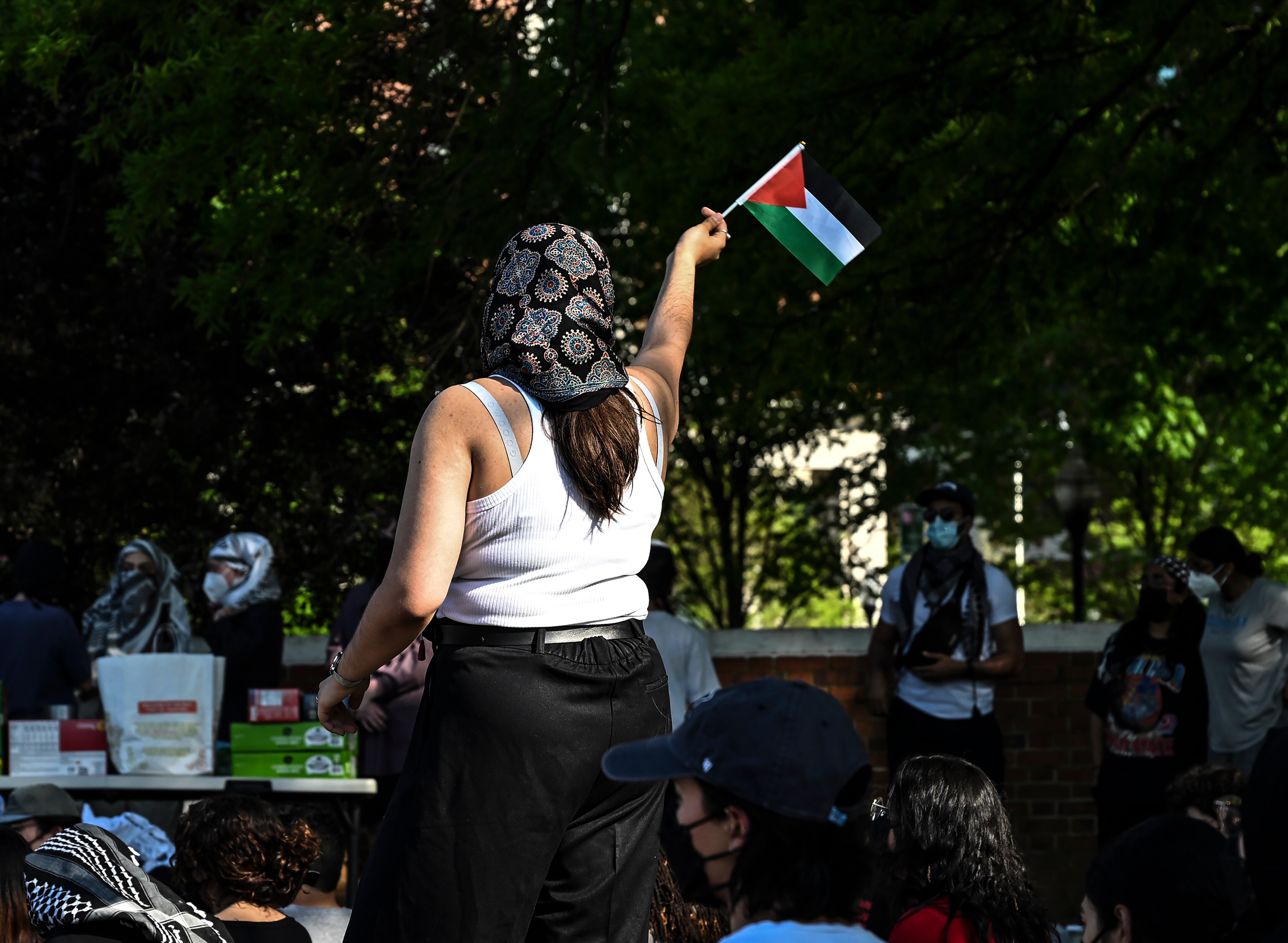A protester waves a Palestinian flag amid a protest on Monday at Johns Hopkins University.
