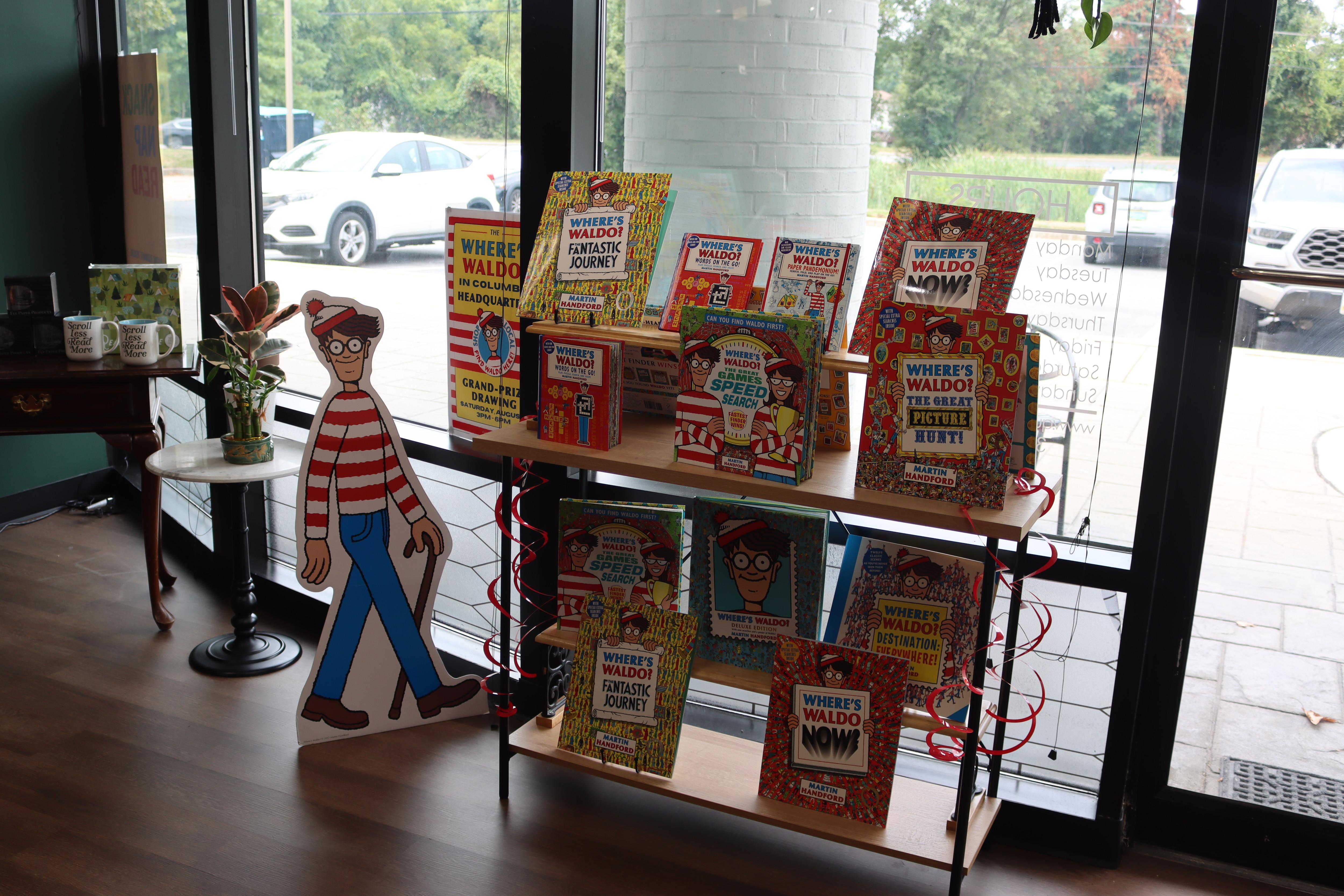A Where's Waldo cutout, the beloved cartoon book character, stands next to a bookshelf full of Waldo books at Queen Takes Book. Through July, Waldo is hiding out in various local businesses in Columbia, Maryland.