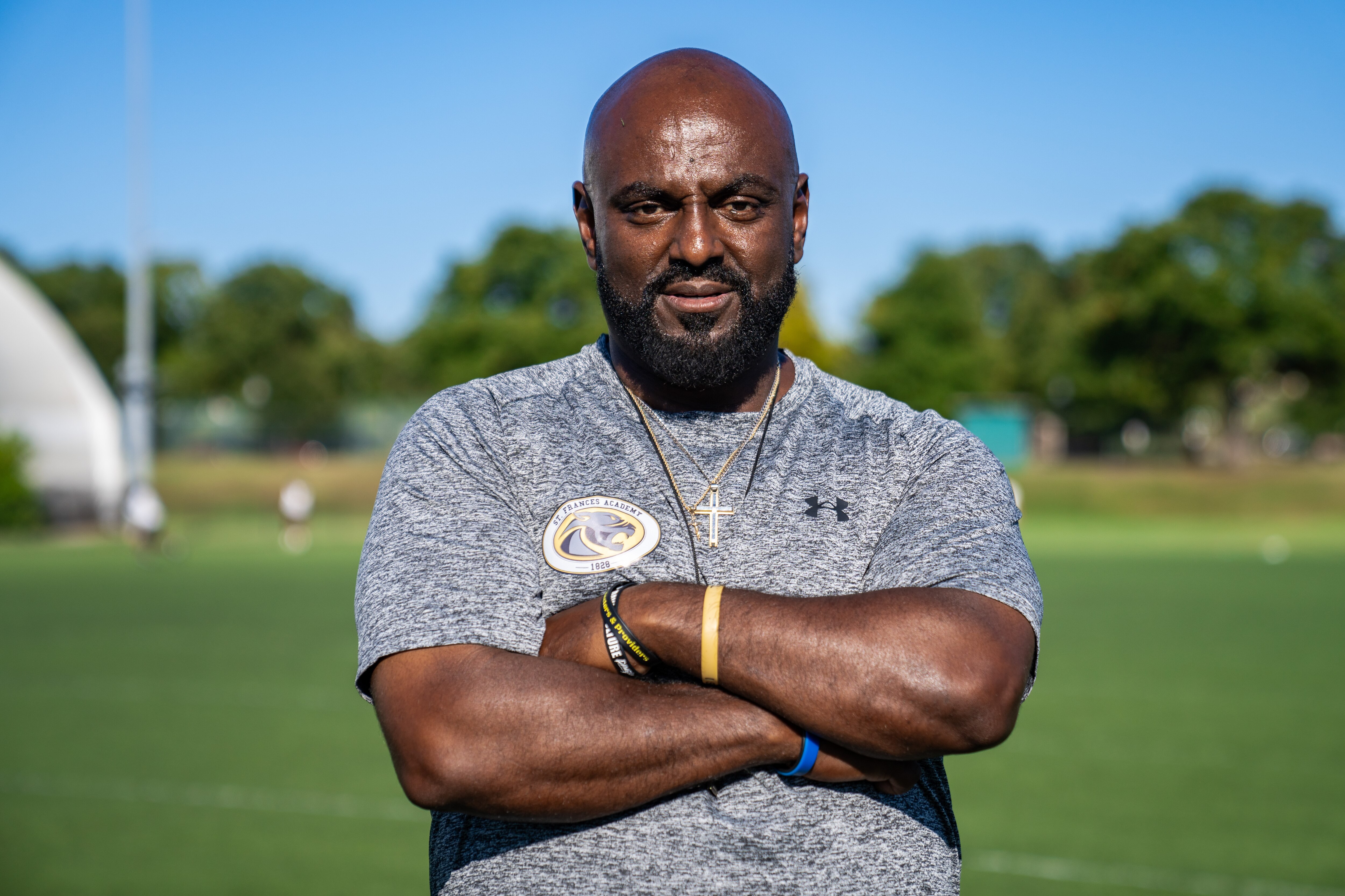 Head coach Messay Hailemariam crosses his arms while posing for a portrait on Patterson Park's football field.