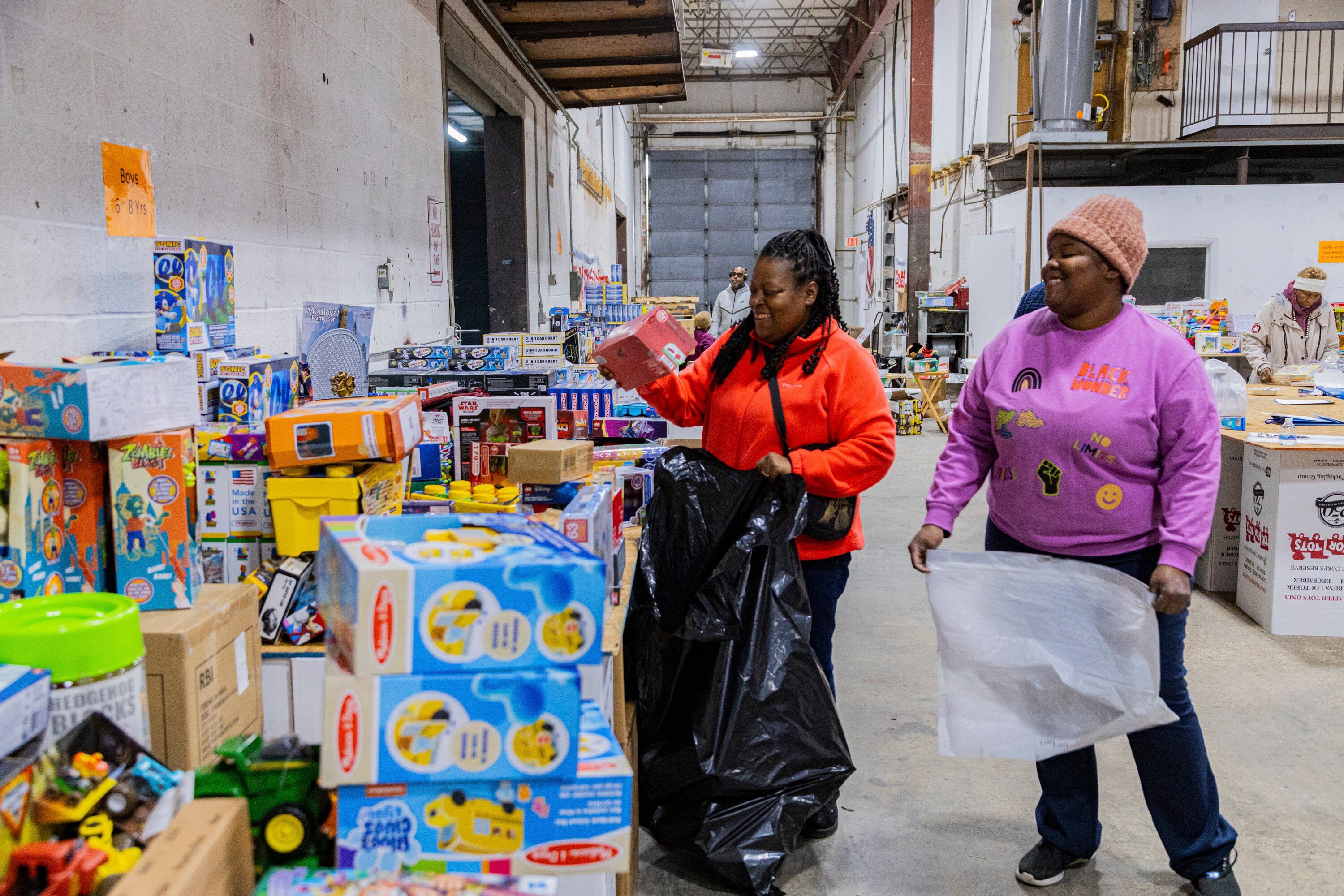 Toys for Tots volunteers Vontice Carter and Crystal Wright pack bags full of toys at the organization’s Gaithersburg warehouse.