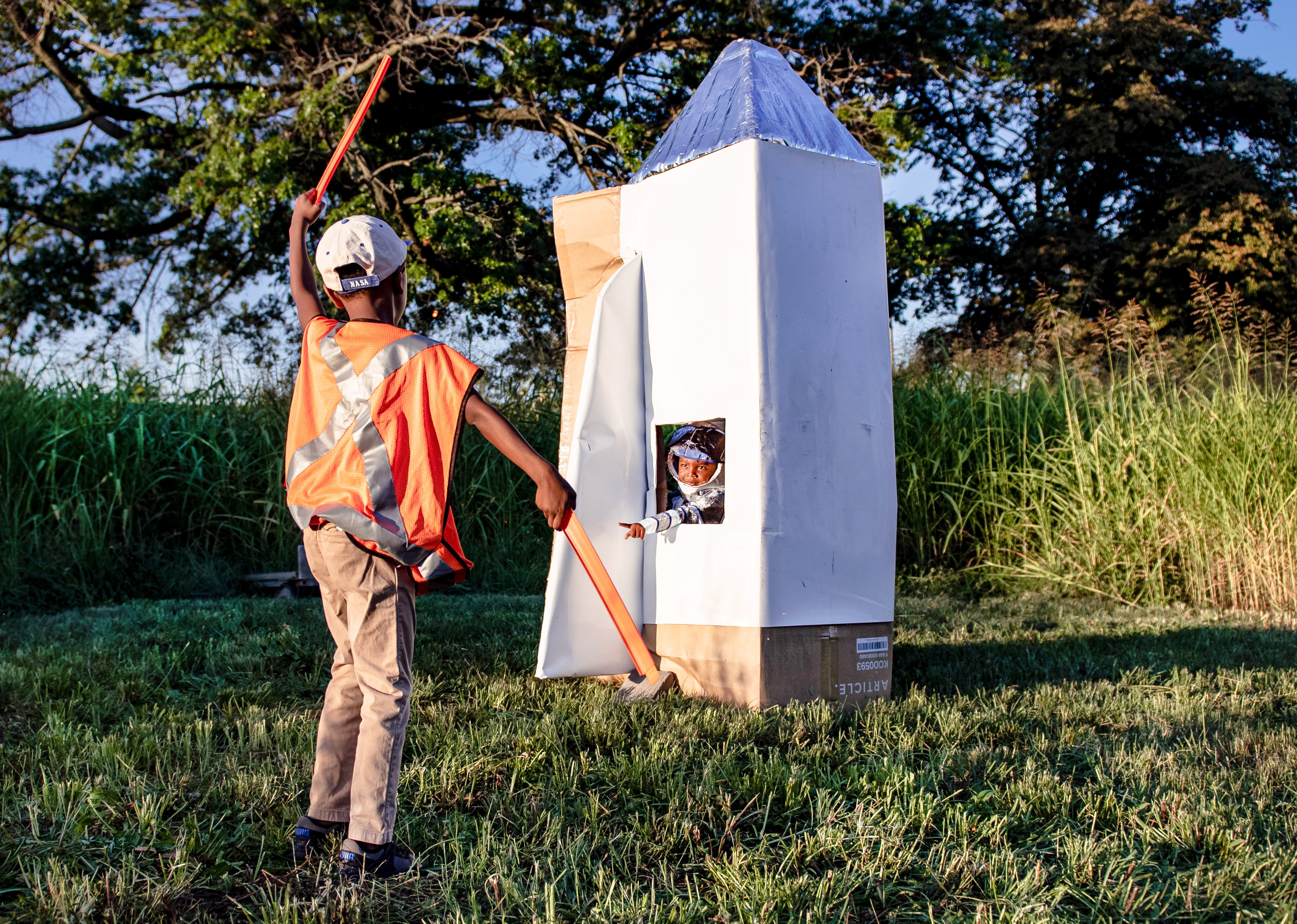 Acting as an air marshal, Noah, 6, signals his brother Aden to prepare for liftoff.