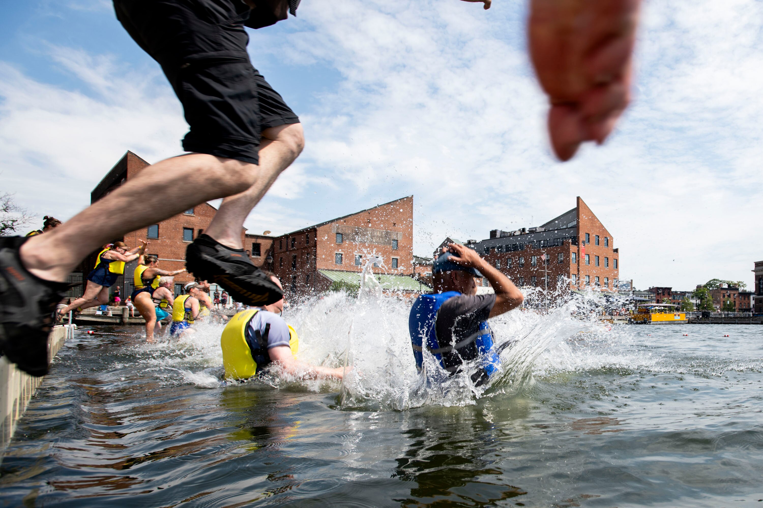 Harbor jumpers leap into the waters of Fells Point during the Harbor Splash 2024 event on 6/23/24 in Baltimore, MD.