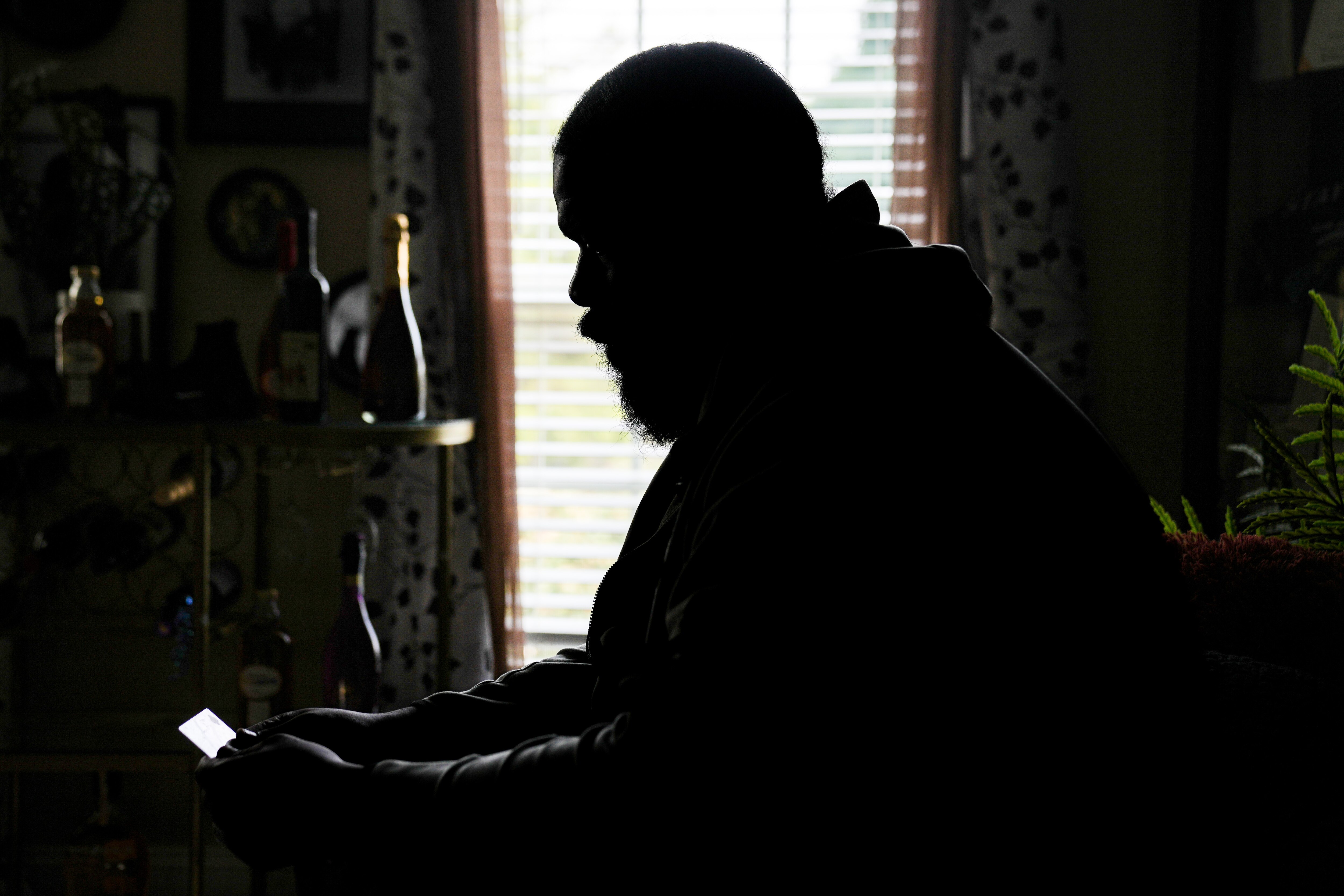 Sunlight reflects off Donte Peoples' driver's license as he examines it in his sister's Randallstown home on Tuesday, July 23, 2024.