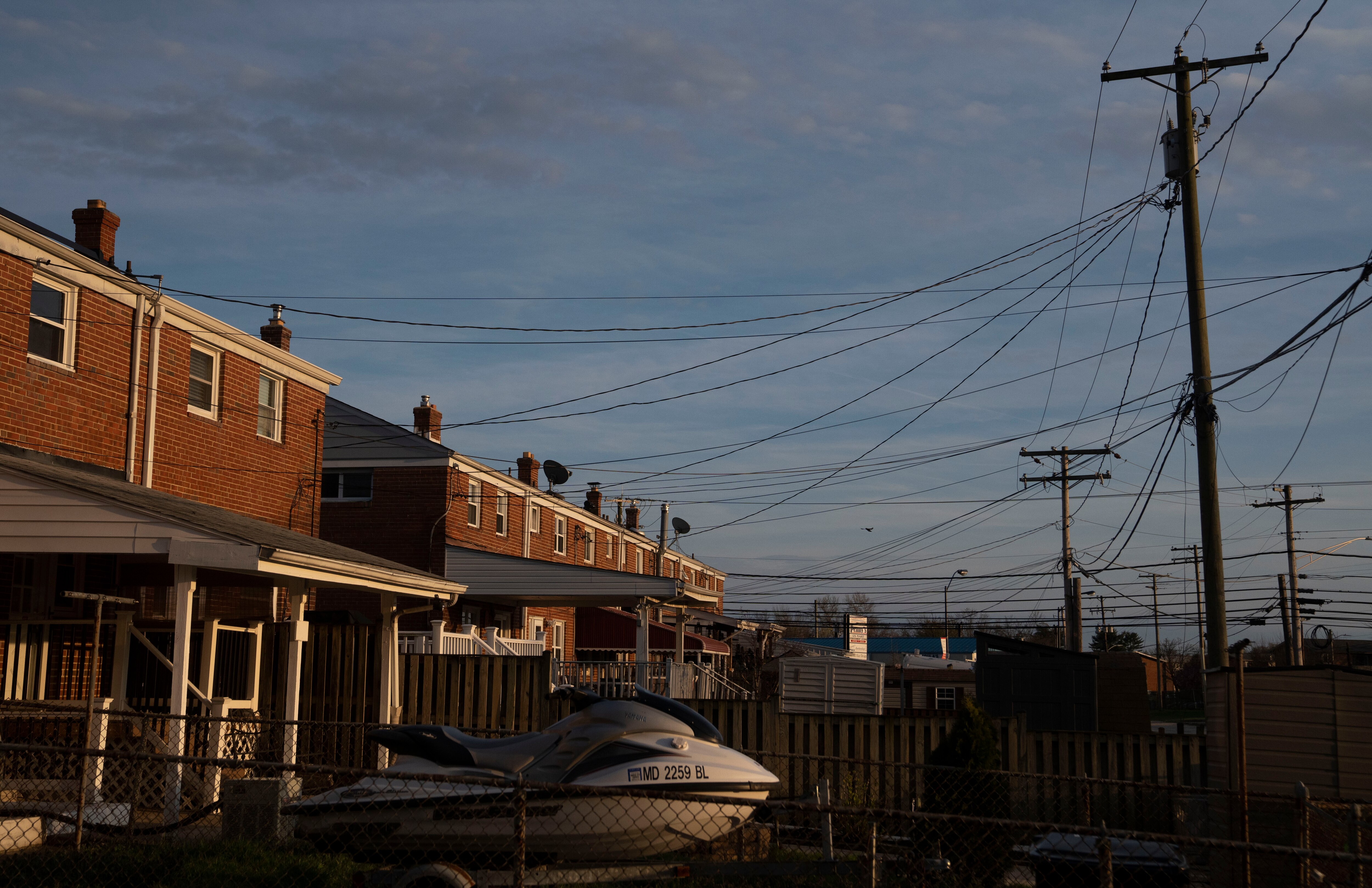 Sun sets in the backyards of homes in Dundalk, the closest community to the Key Bridge.