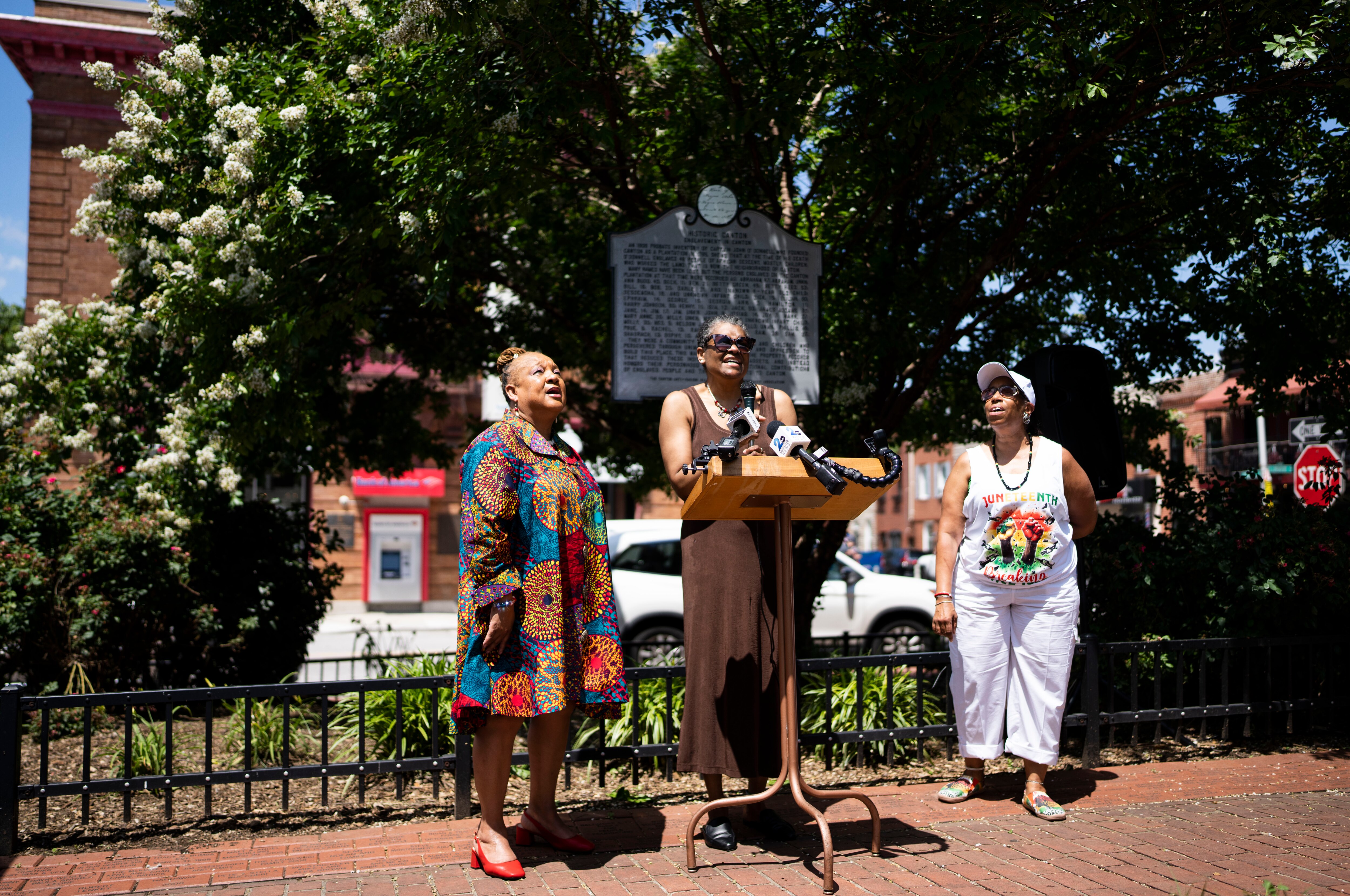 Rev. Marietta, Sheila “She” Anderson with the Canton Anti-Racism Alliance and Denise Glover with United Evangelical Church lead attendees in song during a Juneteenth celebration and historic marker dedication at O'Donnell Square Park on Thursday.