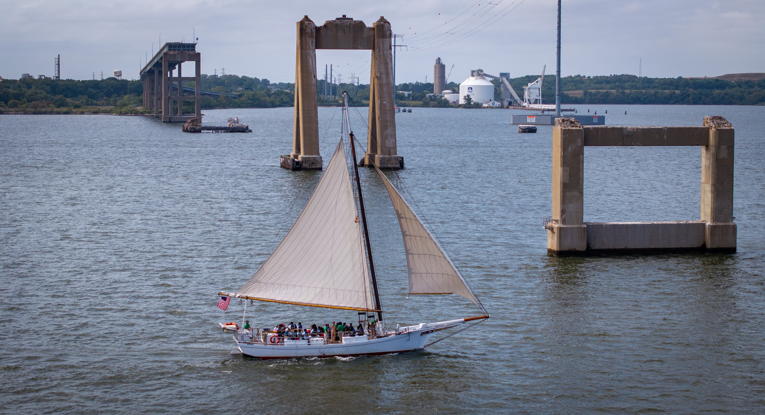 A Chesapeake Bay skipjack sails near the wreckage of the Francis Scott Key Bridge. Work will begin next month to rebuild the bridge.