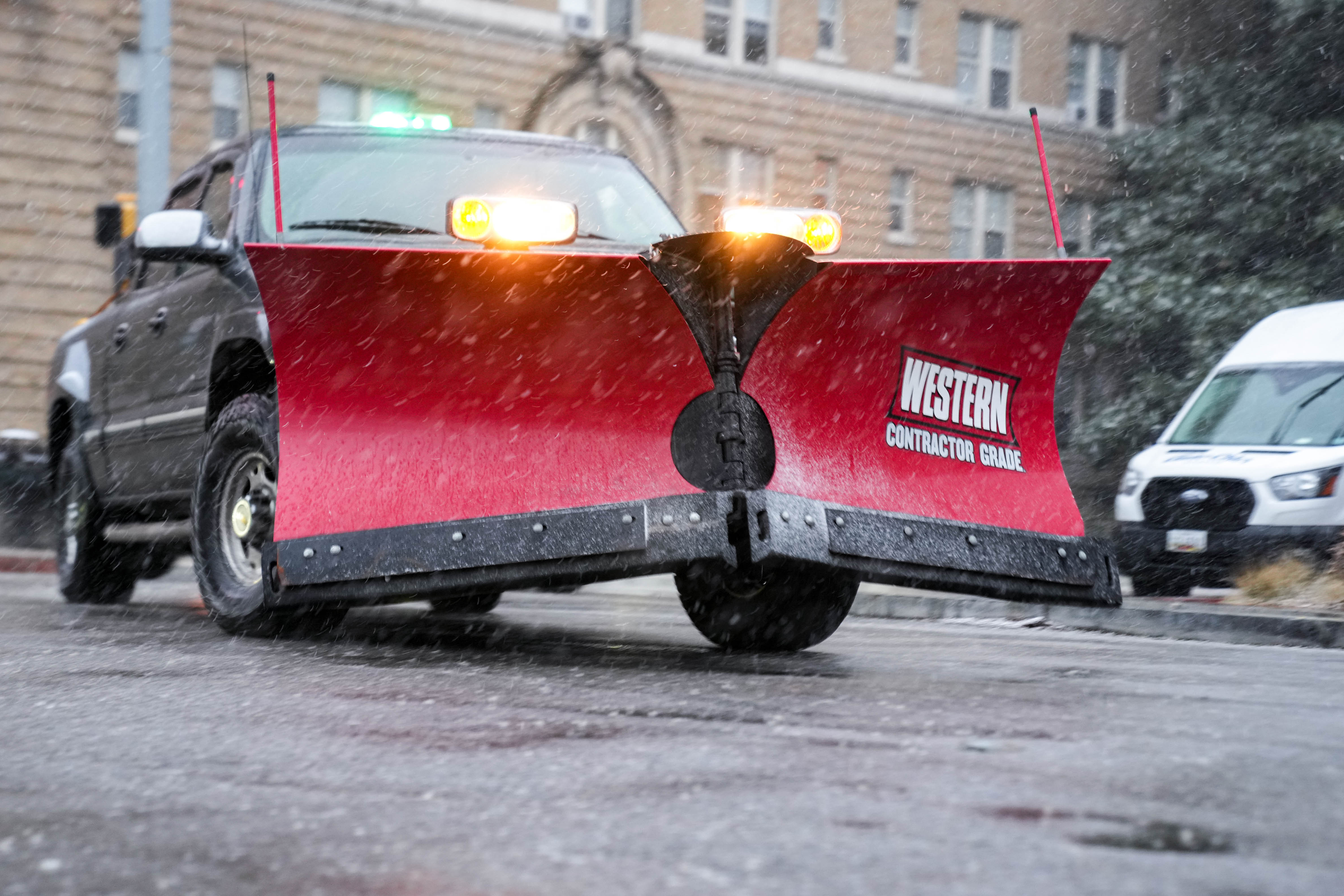 A plow truck drives up 31st St. in Charles Village on a snowy evening in Baltimore, Md. on Tuesday, February 11, 2025.