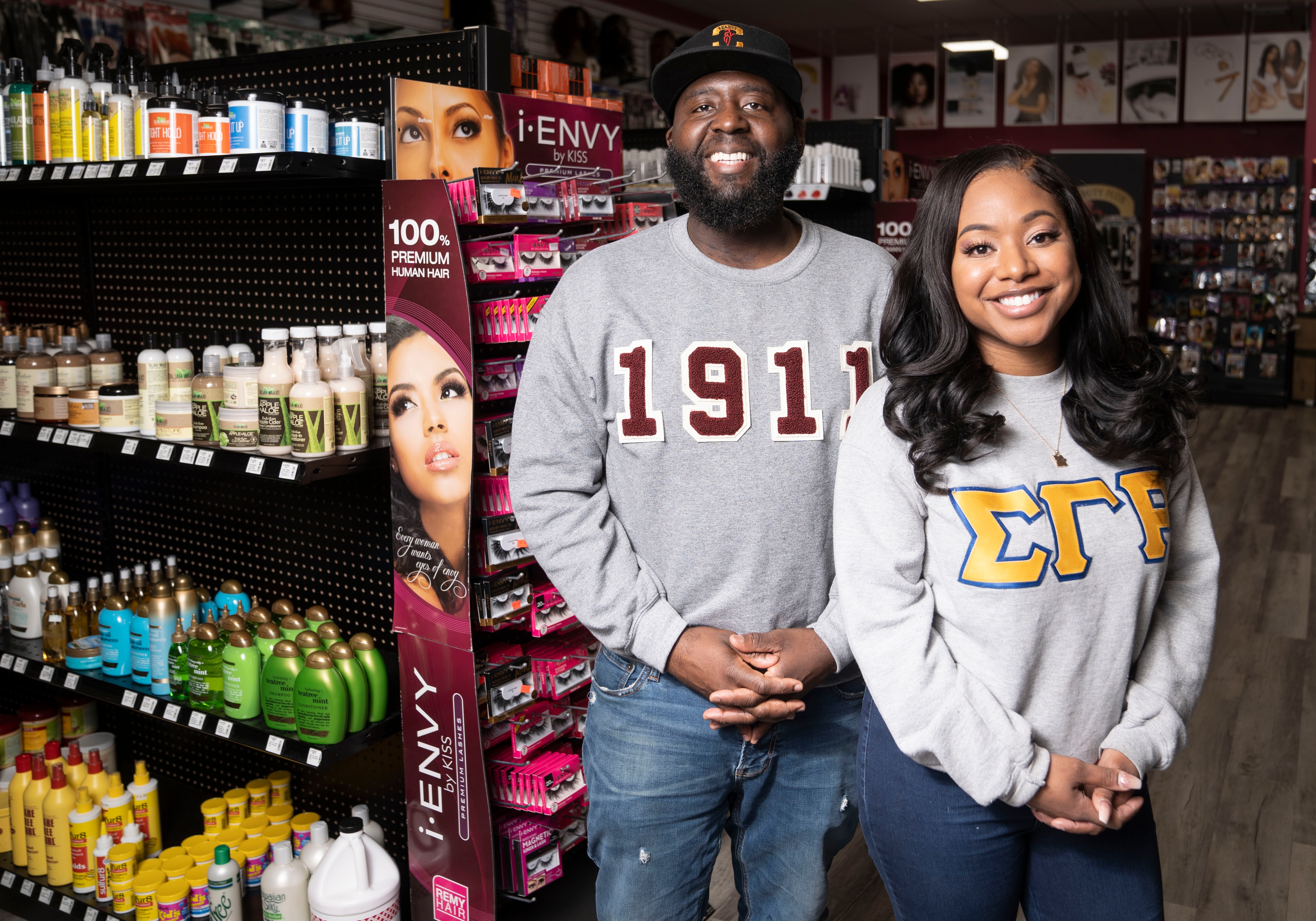 Quintin and Megan Lathan married owners of Beauty Plus poses for a portrait inside of the shop in Baltimore, Friday, February 24, 2023.