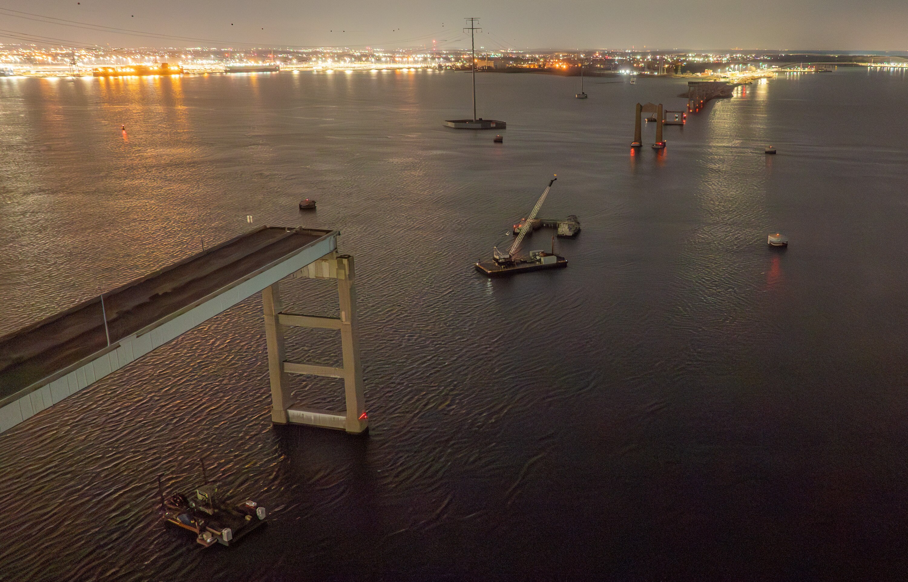 Remnants of the Francis Scott Key Bridge before dawn on the one-year anniversary of its collapse.