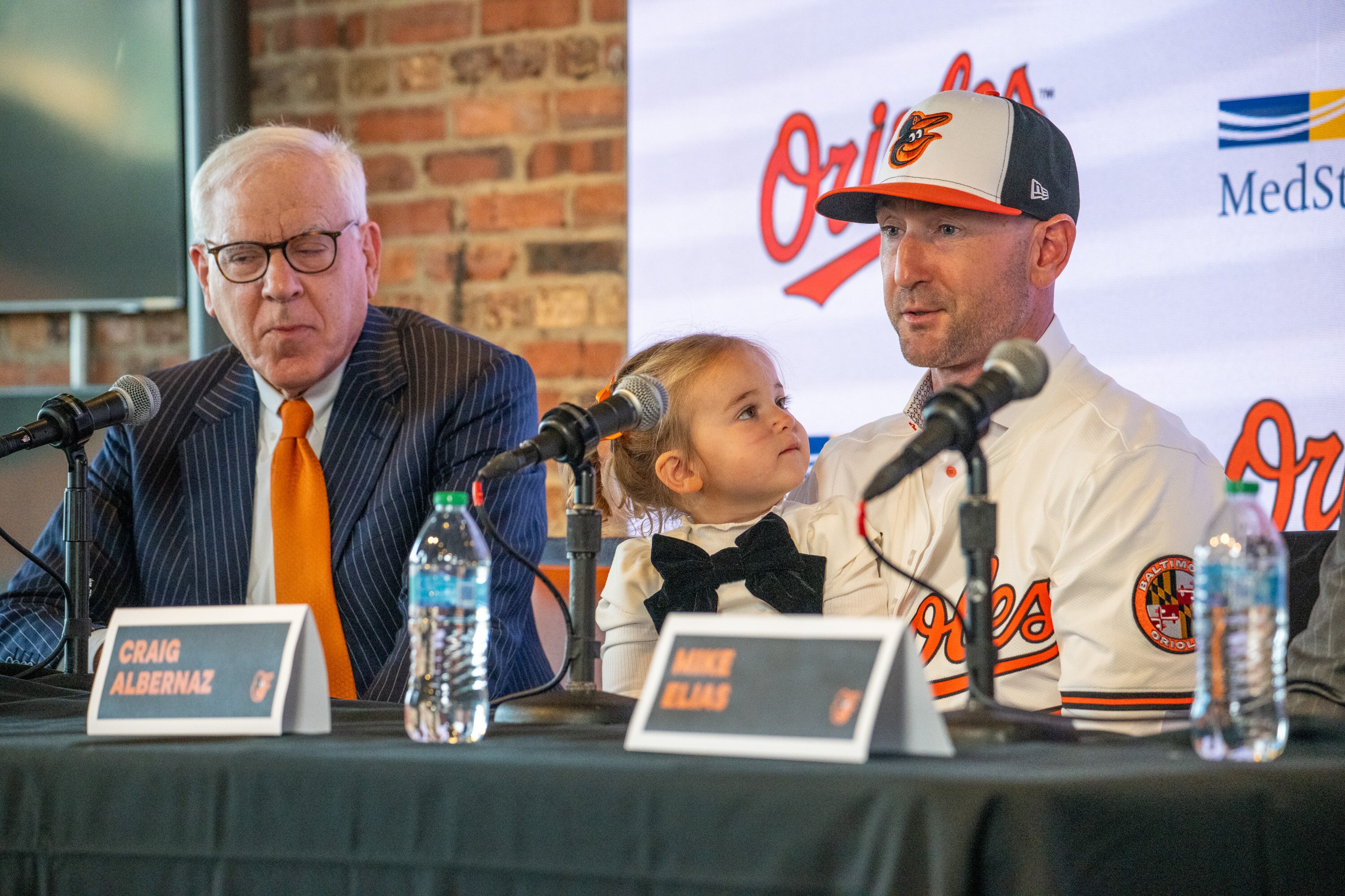 Orioles manager Craig Albernaz, right, holds his 2-year-old daughter, Gigi, as he takes questions at his introductory news conference.
