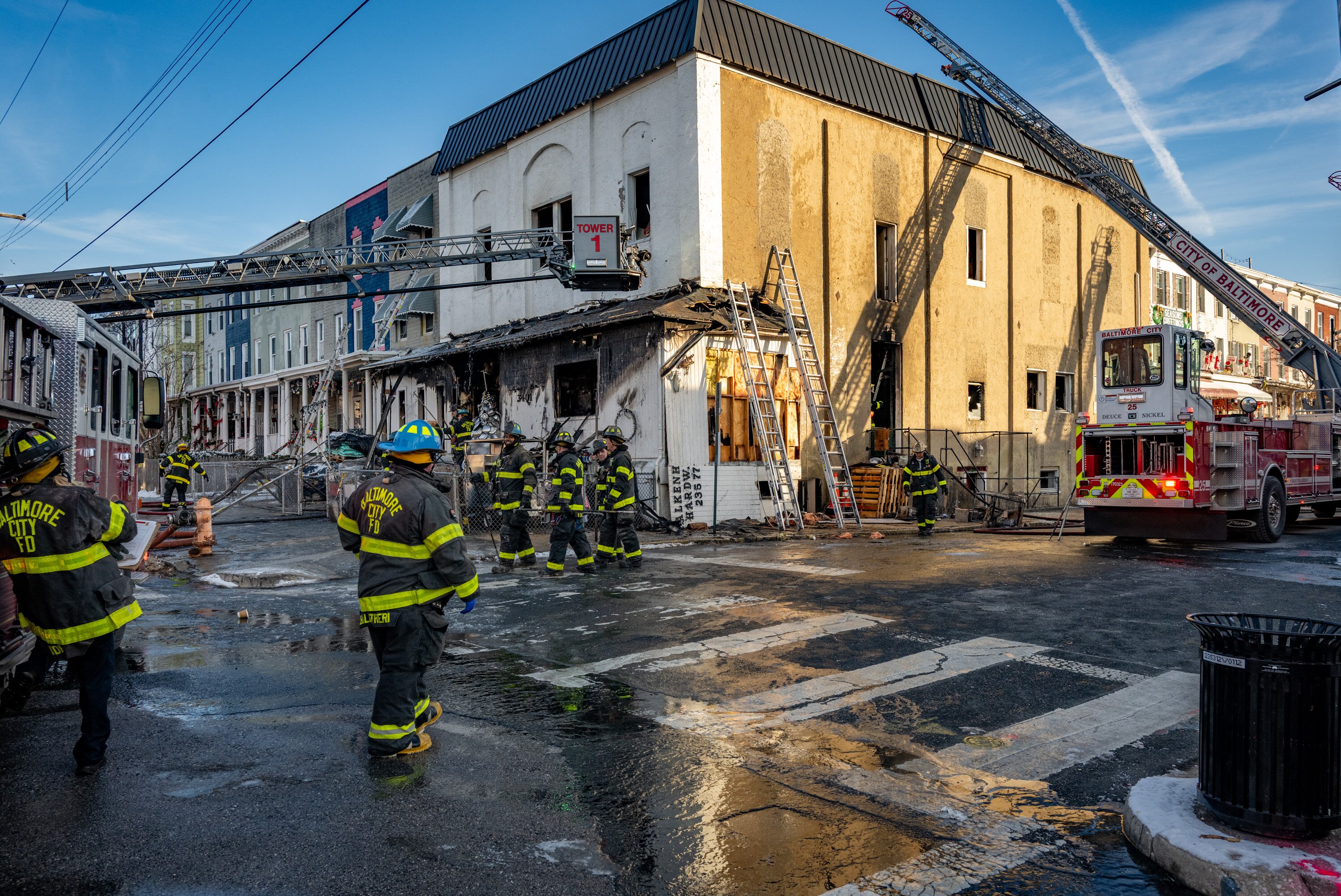Baltimore City Fire Department crews mop up after the blaze at Falkenhan’s Hardware on Monday.