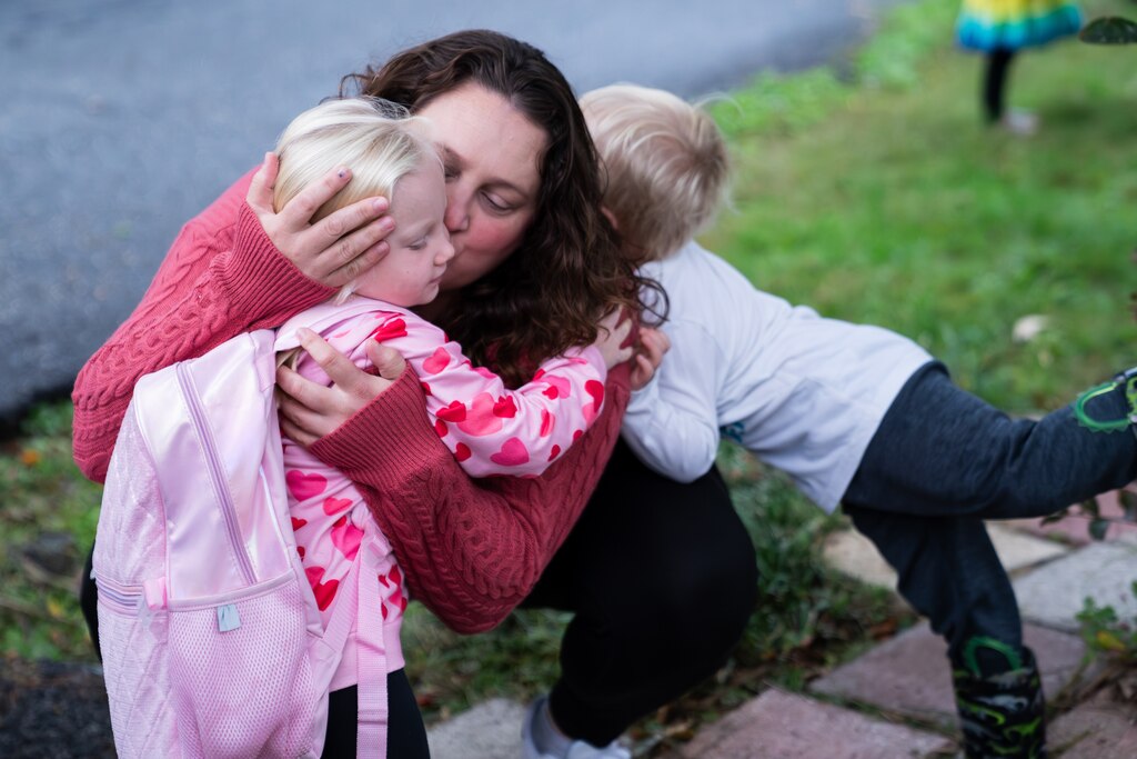 MONDAY, OCTOBER 13, 2025 — Amanda Funk, mother of Ava and Everett Funk, kisses Ava, 5, as she leaves for school at Davidsonville Elementary School at a bus stop in Riva, MD.