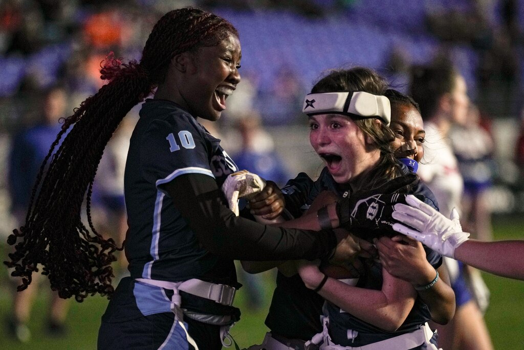 Clarksburg’s Ella Geary (1) is cheered on by Christa Lorfils (10) and other teammates after catching the game-winning touchdown in the 2024 Maryland High School Girls Flag Football Championship