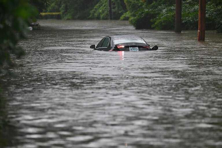 Thursday, July 31, 2025 — A Mercedes sits in floodwater on Ruxton Road where Roland Run spilled over its banks during the afternoon thunderstorms that moved through the region.