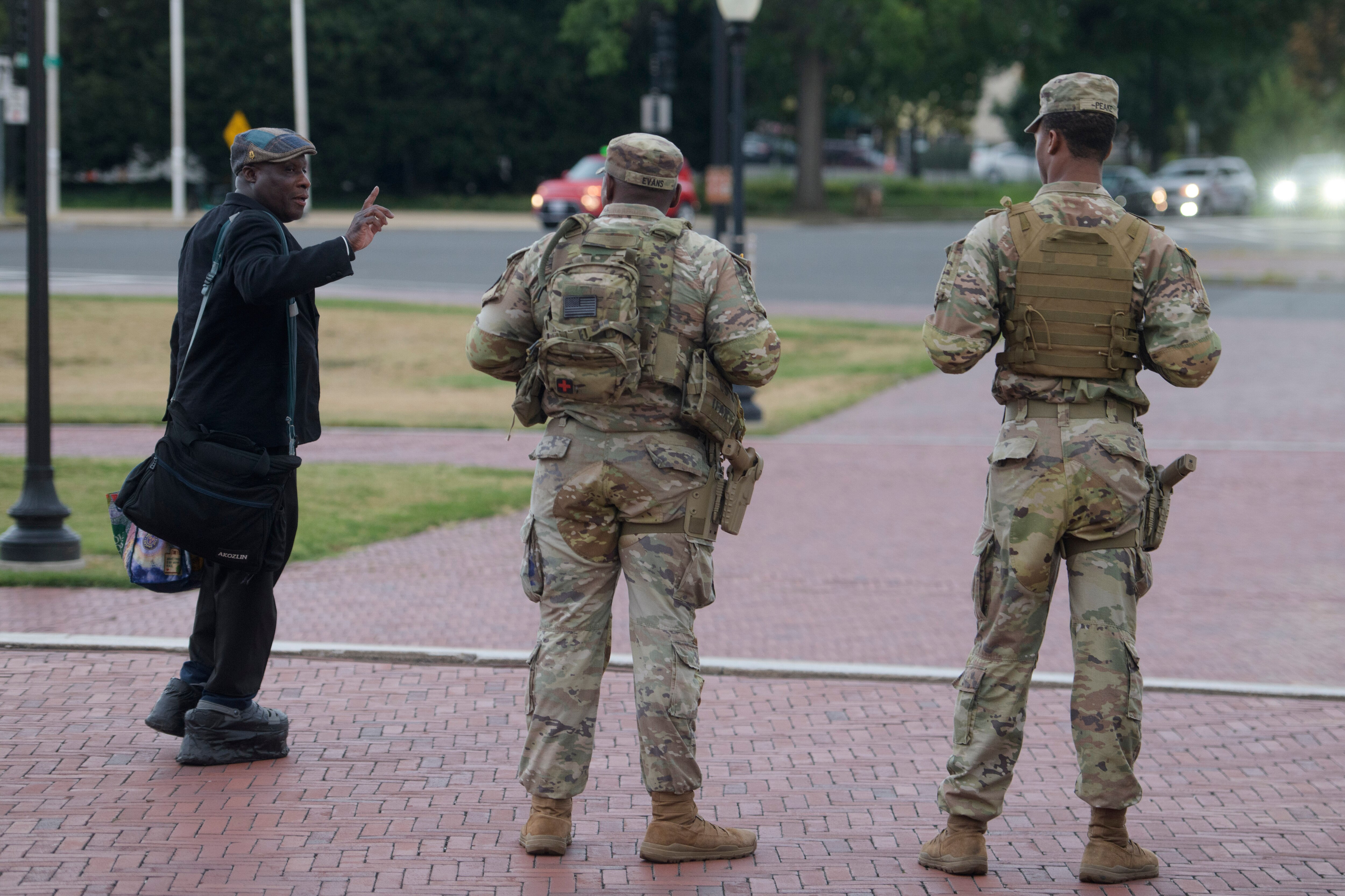 Armed members of the South Carolina National Guard talk with a man while positioned outside of Union Station in Washington, Sunday, Aug. 24, 2025. (AP Photo/Rod Lamkey, Jr.)