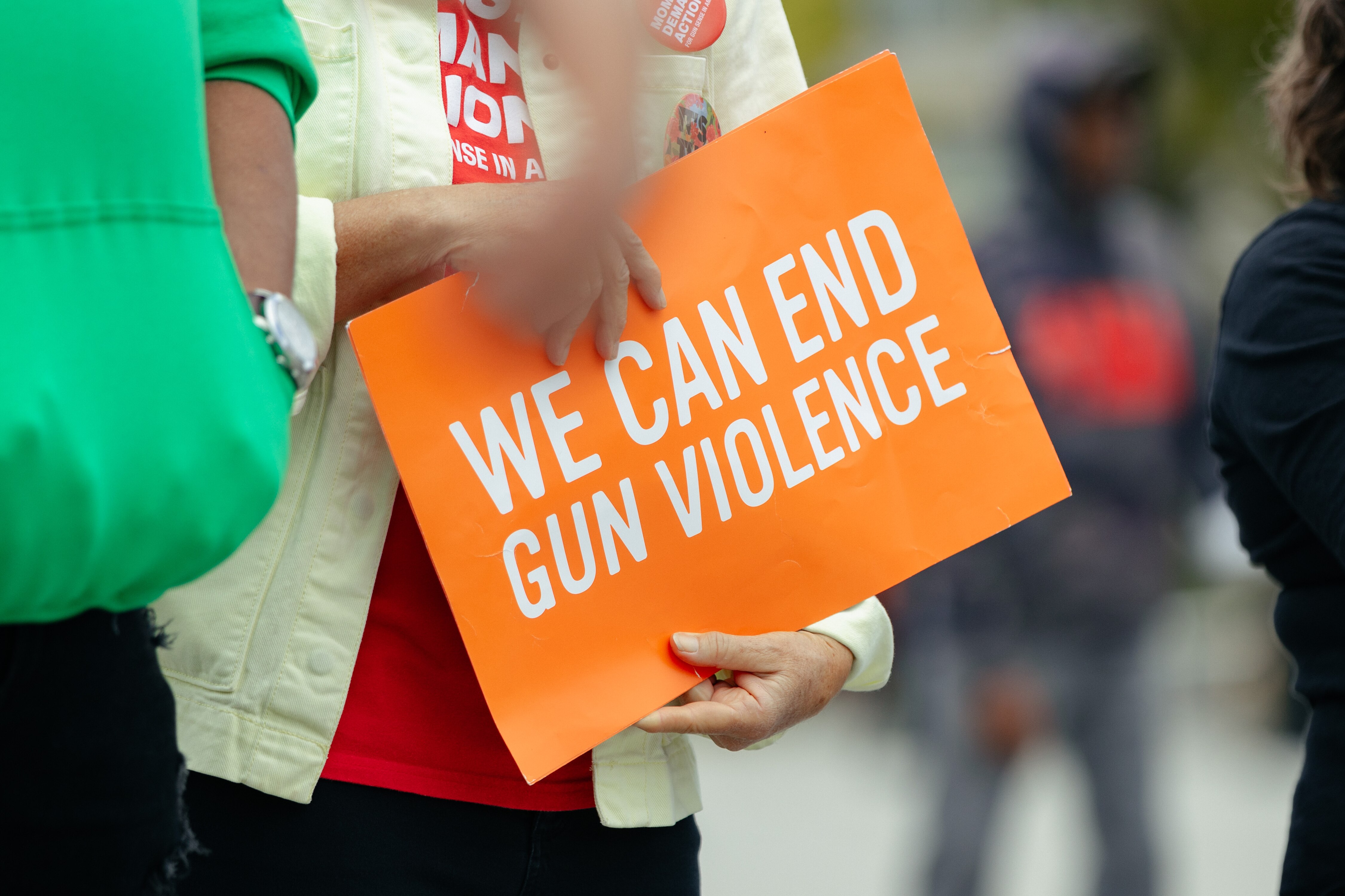Attendants of an anti-gun violence event organized by We Our Us hold a sign during speeches on Saturday, Oct. 21, 2023 in Baltimore, MD.