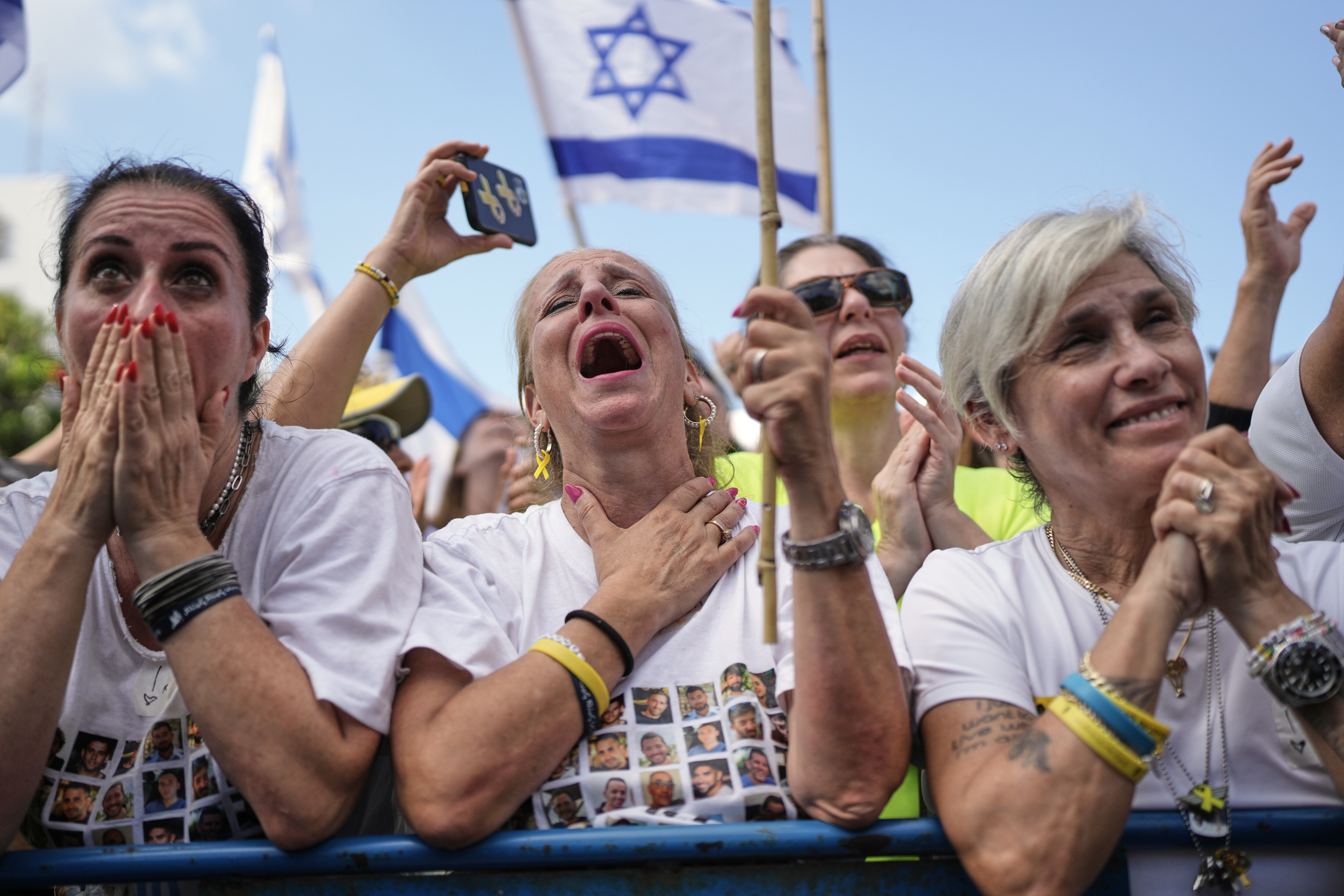 People react as they gather to watch a live broadcast of Israeli hostages released from Gaza at a plaza known as hostages square in Tel Aviv, Israel, Monday, Oct. 13, 2025. (AP Photo/Oded Balilty)