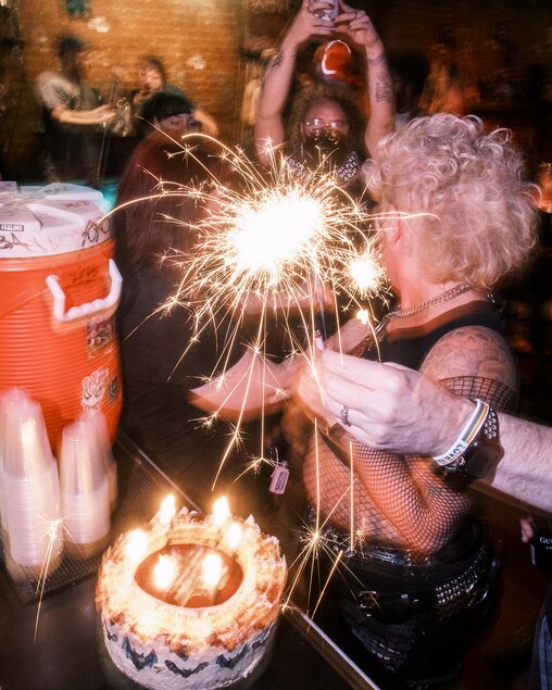 Friends light the candles on the Ozzy Bat themed tres leches cake during Metal Monday at Ottobar in Baltimore on Monday, July 28, 2025.