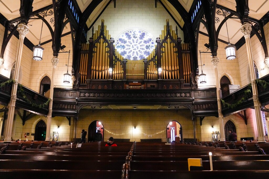 Visitors peruse the books on display and read through them in the pews during the Ivy Bookshop’s pop-up event inside the Mount Vernon Place United Methodist Church and Asbury House in Baltimore, Md. on Thursday, December 4, 2025.