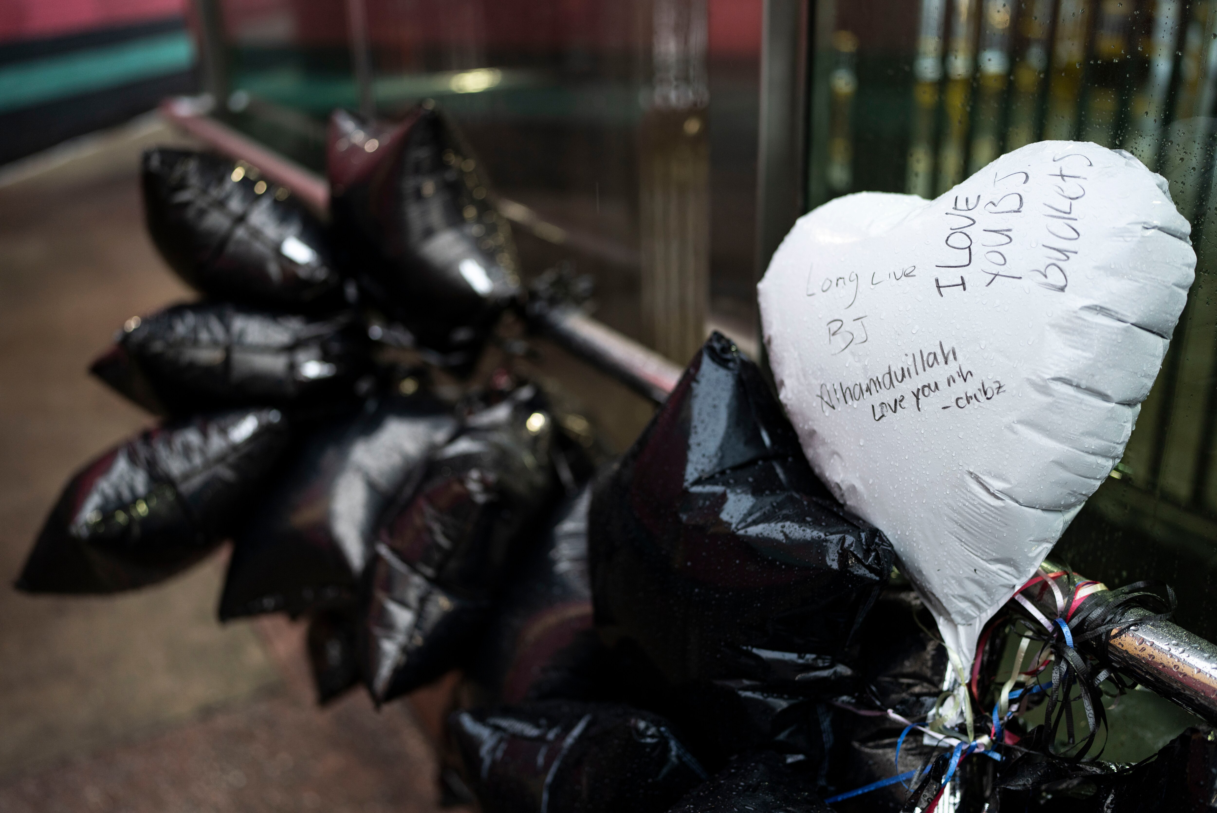 Balloons tied to the railing outside Upton–Avenue Market Metro station on Thursday to honor Bilal “BJ” Abdullah, who was fatally shot by Baltimore Police this week.