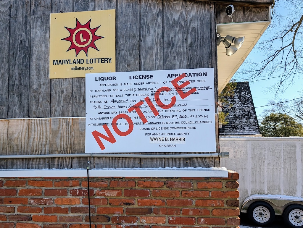 An outdated public notice for a hearing on the Magothy Inn liquor license is still posted on the outside wall.