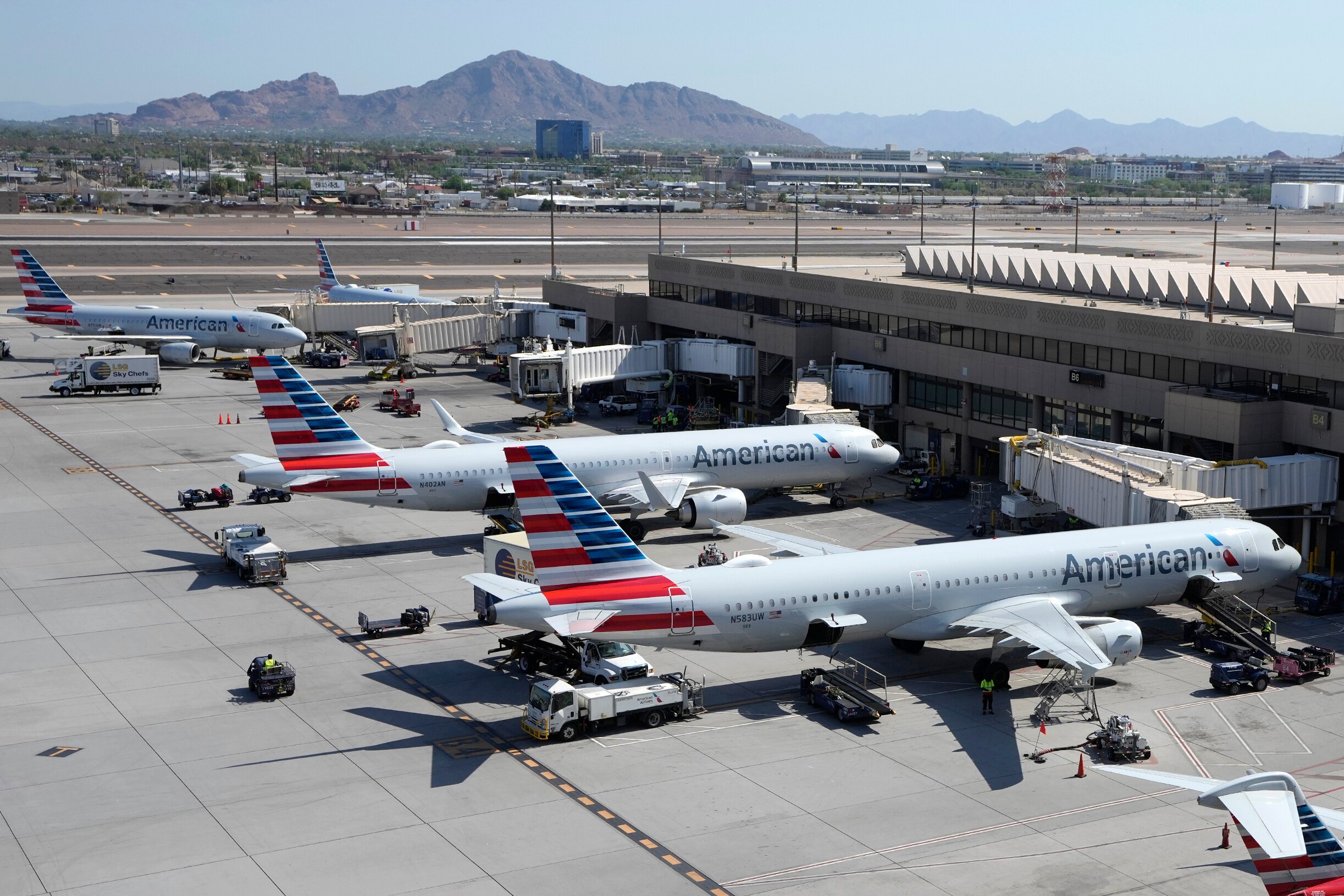 American Airlines planes wait at gates at Phoenix Sky Harbor International Airport Friday, July 19, 2024, in Phoenix, Arizona.