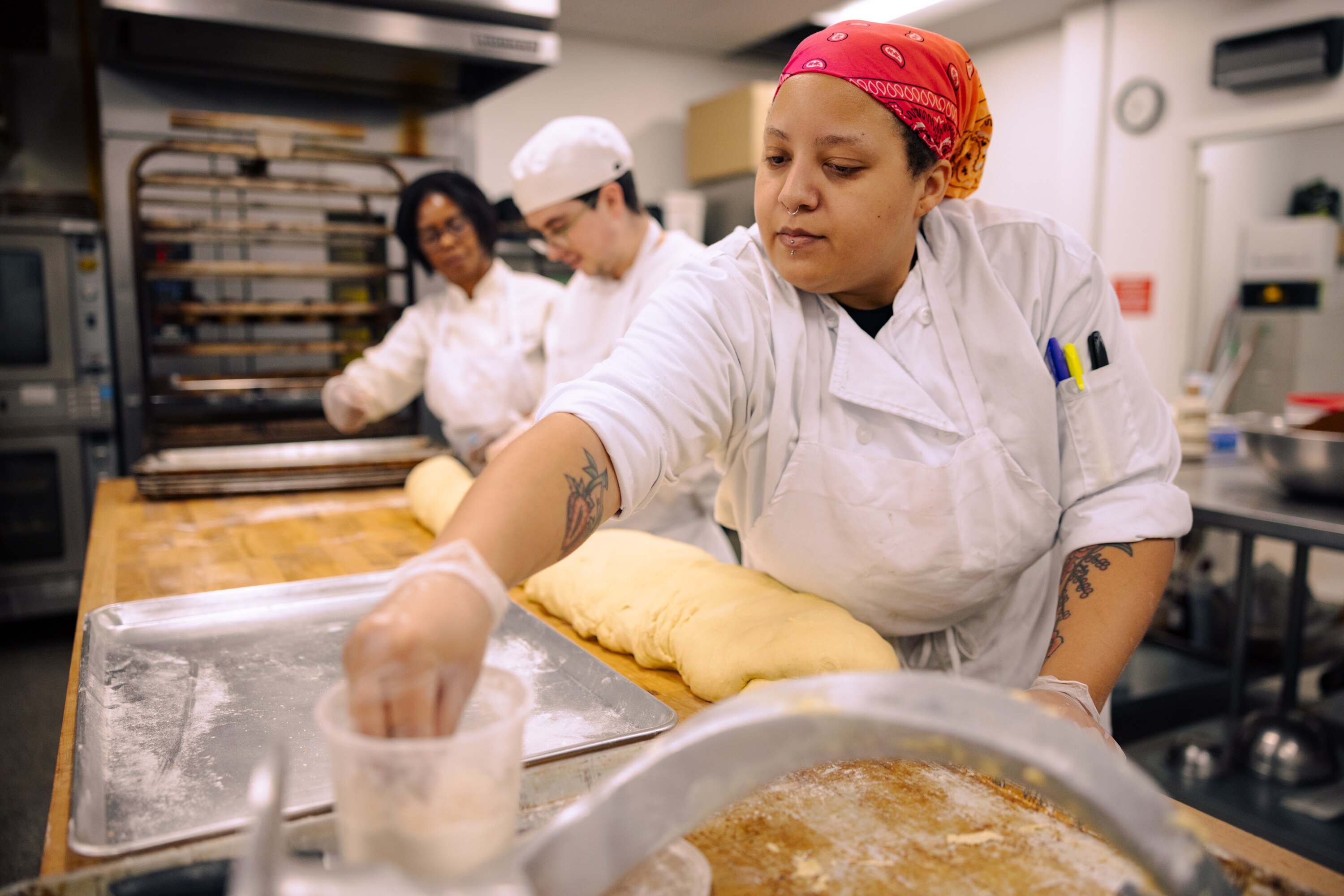 Marion Pitcher, left, pastry chef instructor, works alongside Kareem Amaout and Courtney Wheeler at Sunflower Bakery in Rockville.
