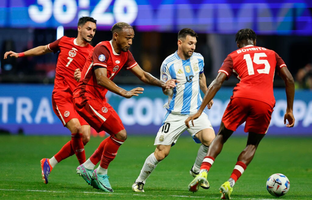 Derek Cornelius and Moïse Bombito of Canada battle for the ball Lionel Messi.