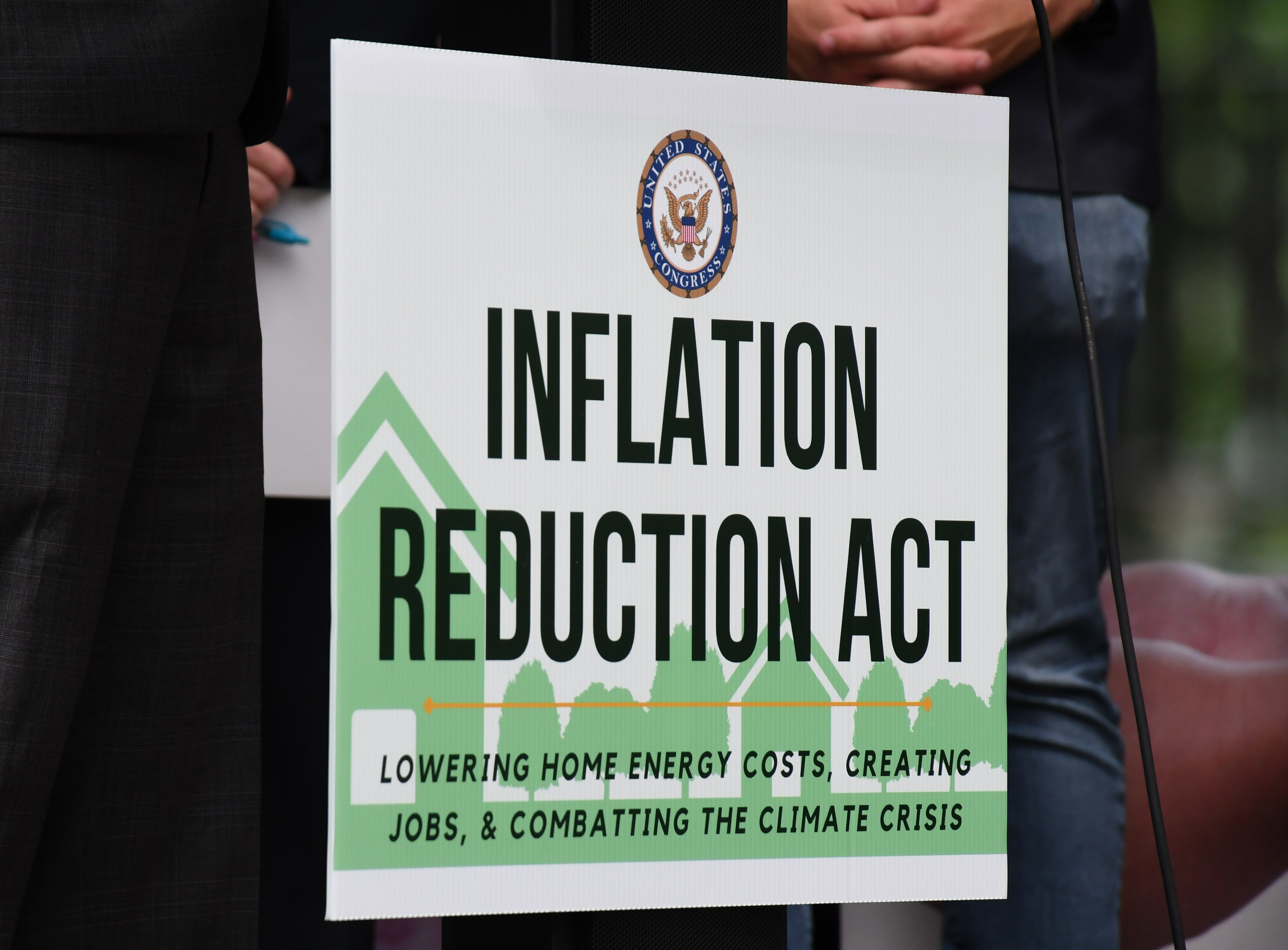 A sign promotes the Inflation Reduction Act during an event at the headquarters of the Green & Healthy Homes Initiative in Baltimore's Canton neighborhood on Monday, Aug. 15, 2022.