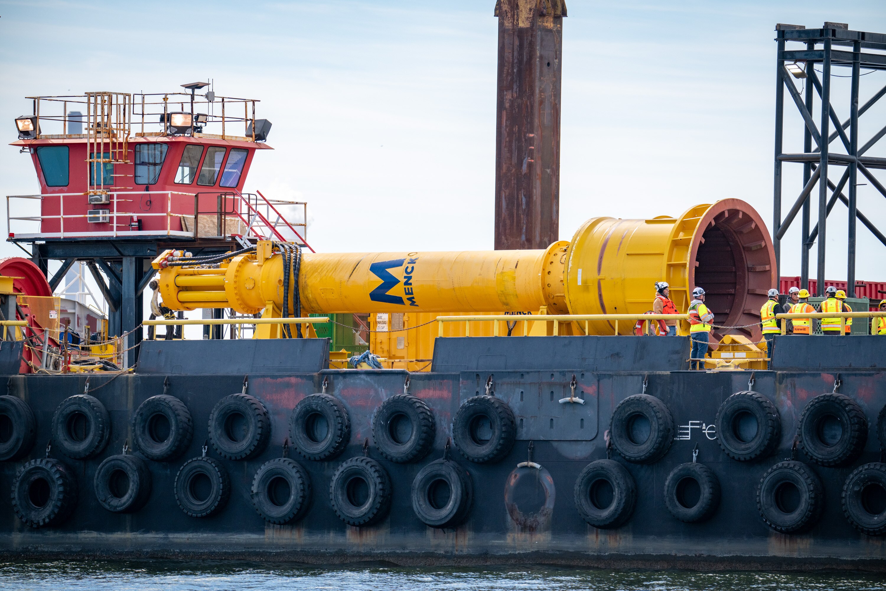 A massive hydraulic hammer used to drive test piles into the Patapsco River bed sits aboard a Weeks 533 crane barge at the Key Bridge site on Wednesday.