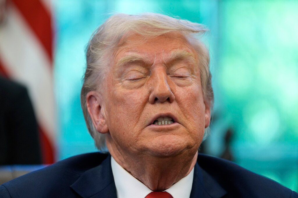 President Donald Trump speaks with reporters after signing executive orders in the Oval Office.