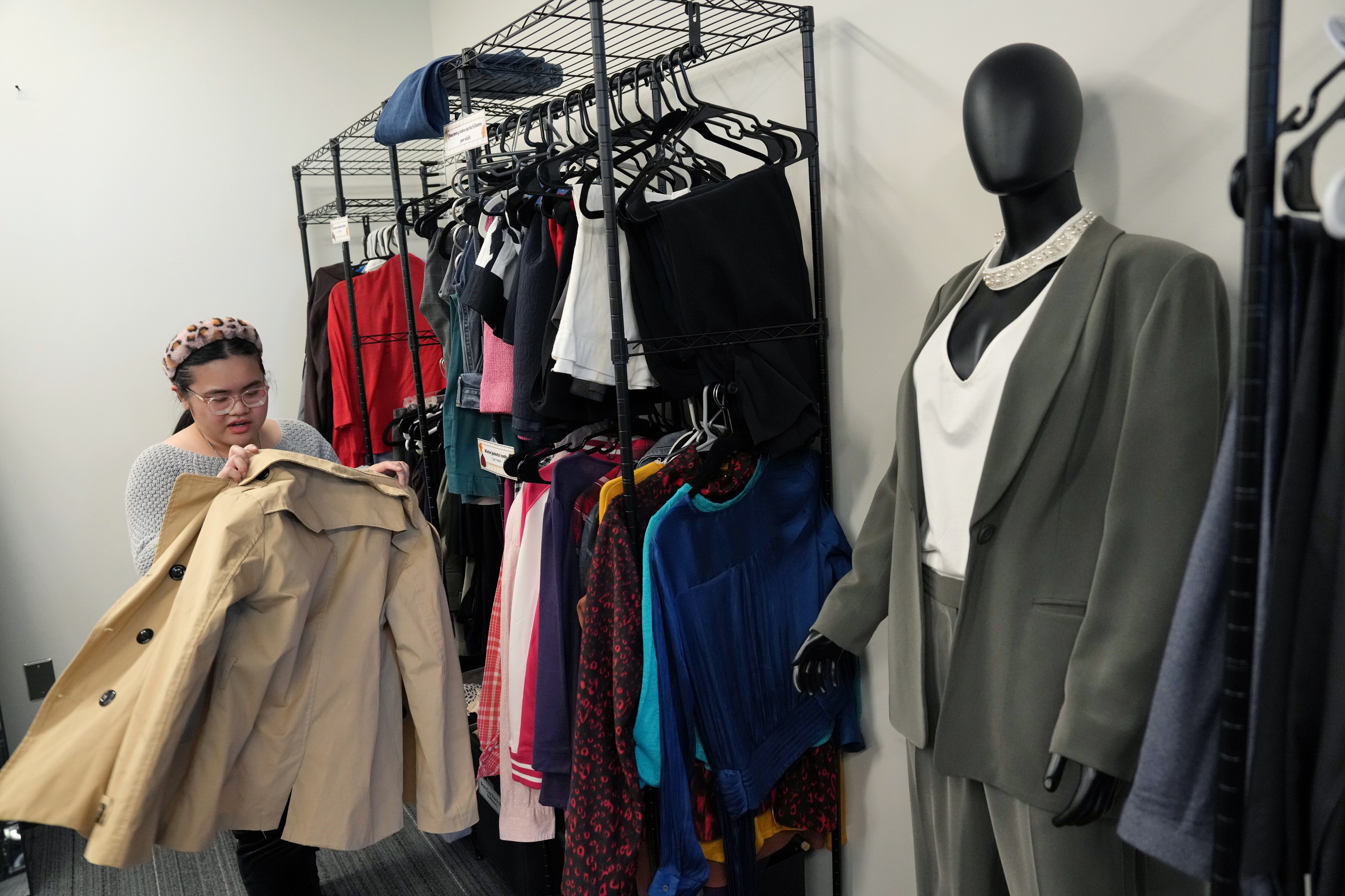 Student Sophia Dizon tries on a jacket as she peruses items with other students in the SPIFFY Closet at Montgomery College in Rockville.