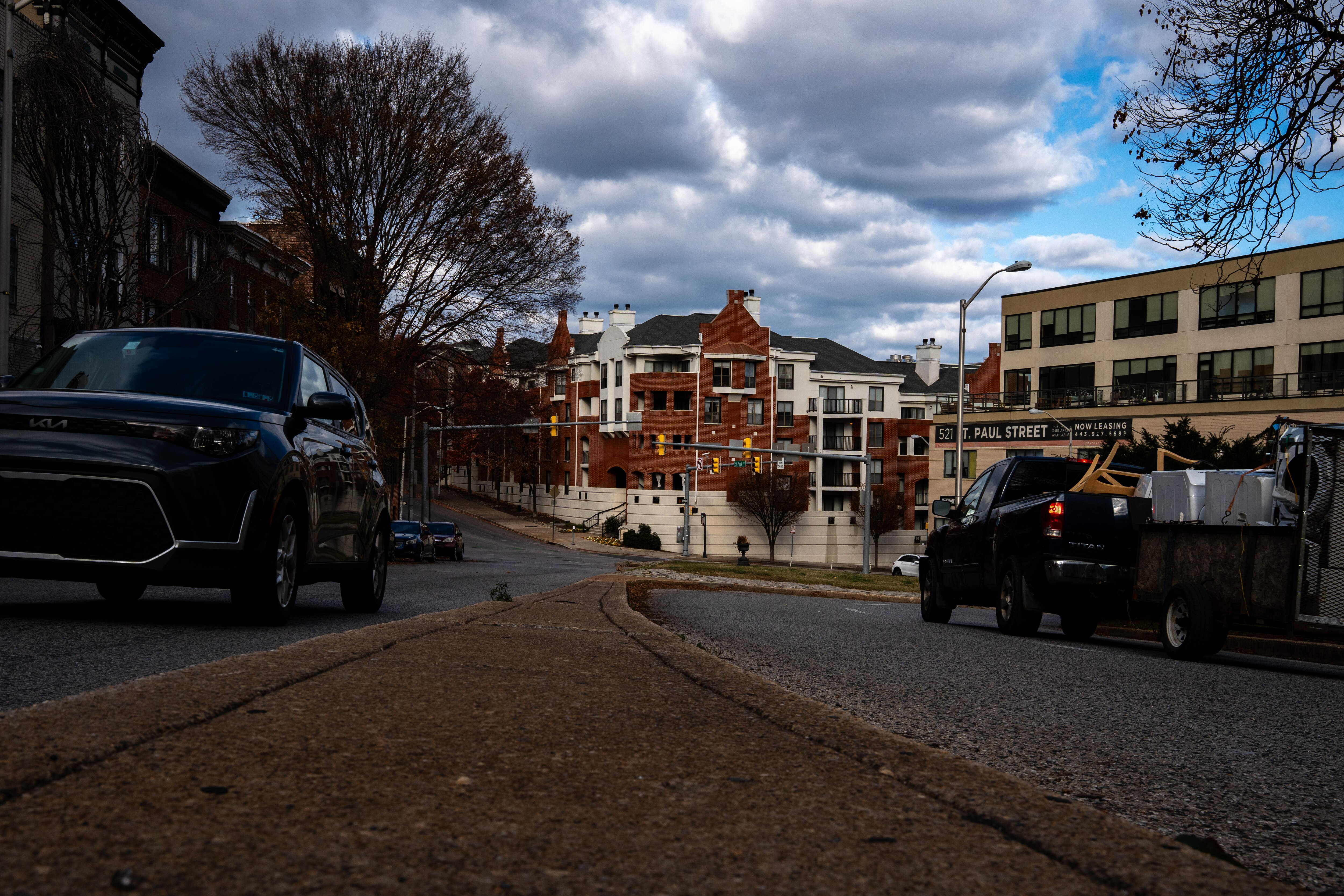 Cars drive past the 500 block of St. Paul St. on Friday, Nov. 28, 2025, where a 49-year-old woman from Northeast Baltimore was arrested last month and charged with fatally beating a city traffic worker during an argument over a parking spot.
