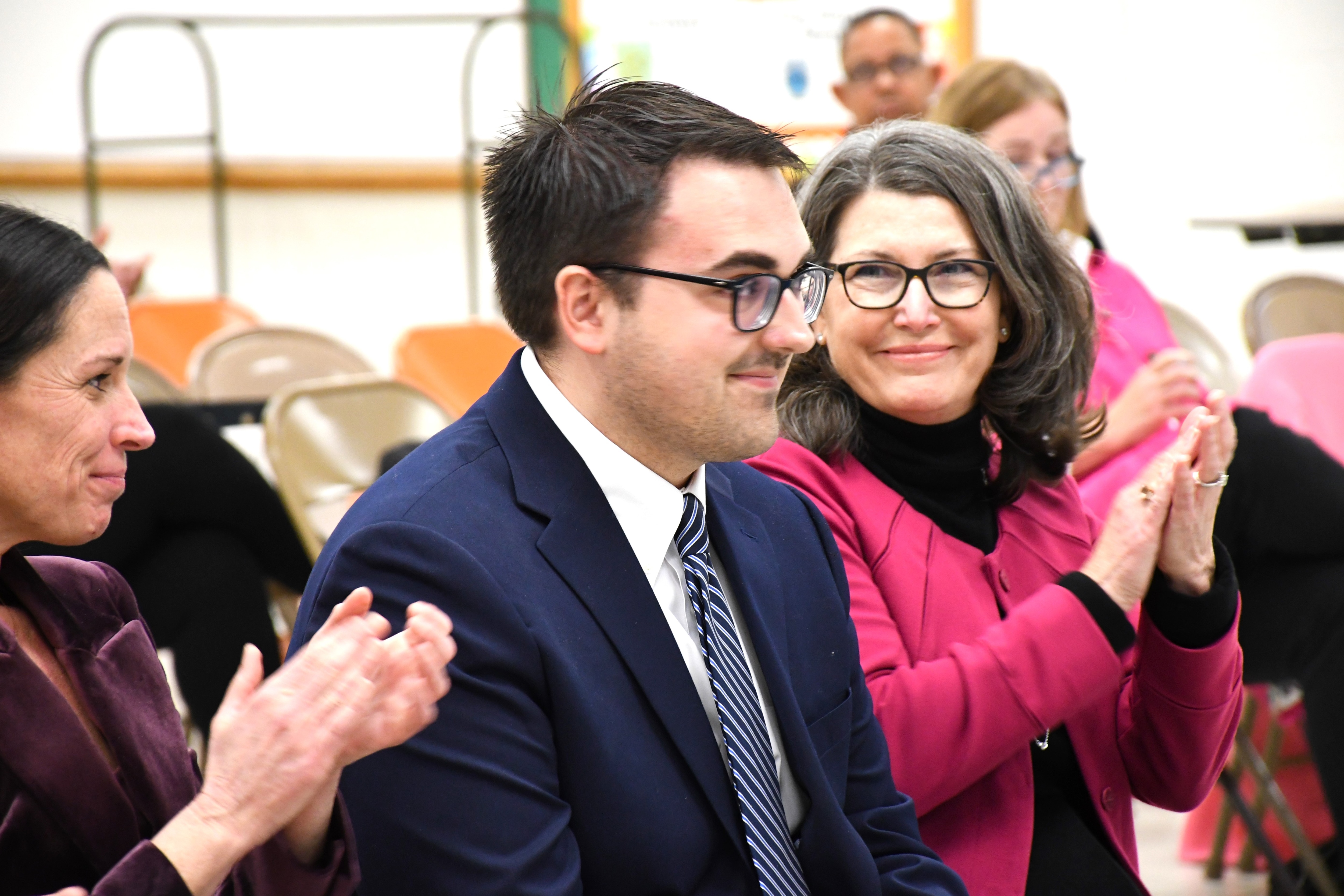 Dylan Behler, center, is applauded by fellow candidates after being nominated by the Anne Arundel County Democratic Central Committee to fill a vacancy in the House of Delegates, during a meeting at Annapolis Middle School on Saturday, Feb. 2, 2025. To the left is Abigail Diehl and to the right is Chrissy Holt.