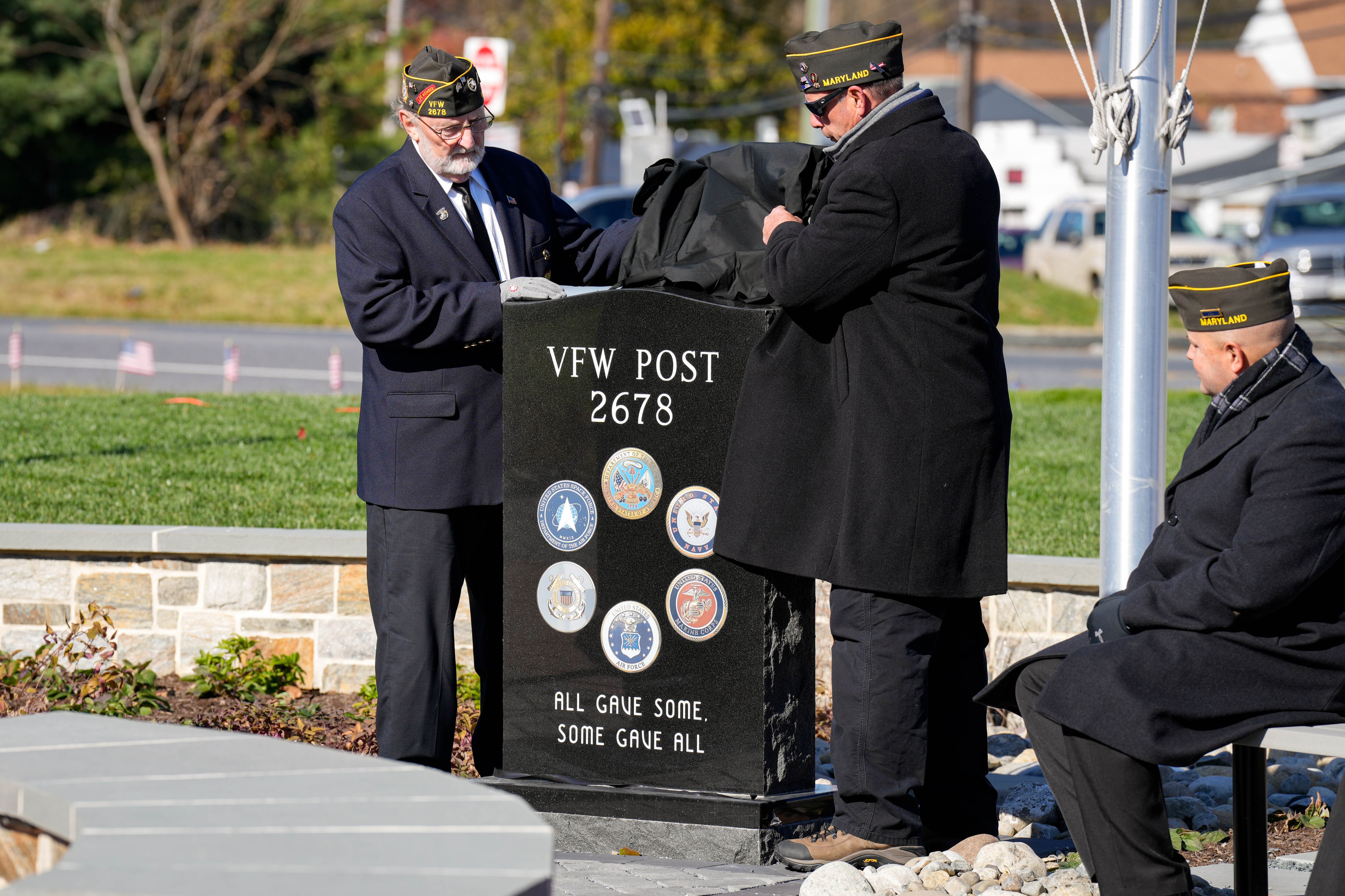 Post Commander Dan Woolfrey, left, and Keith Taylor, project manager on the memorial’s dedication committee, unveil a commemorative monument at Veterans Memorial Park on Tuesday.