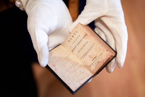Christine Hughes holds a historical book of hymns found inside Emmarts United Methodist Church in Windsor Mill, Md. on Saturday, February 1, 2025. The church, a historic safehouse on the Underground Railroad, hosted a program to commemorate the start of Black History Month on Saturday.
