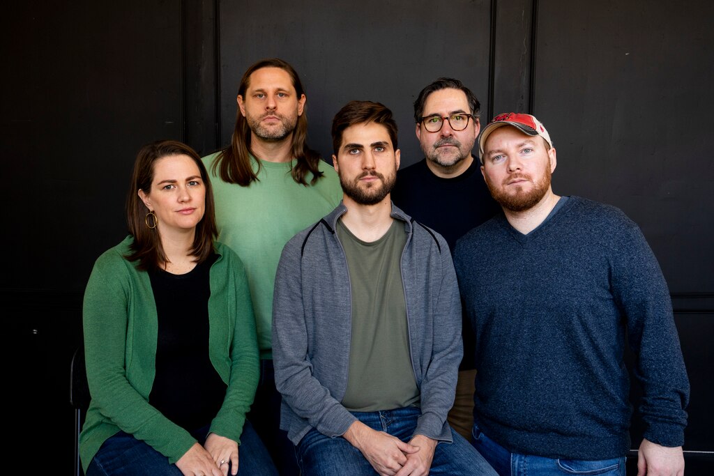 Photograph of five white adults grouped in two rows, four men and one woman.
