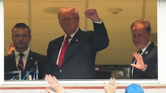 President Donald Trump, center, gestures to the crowd alongside Defense Secretary Pete Hegseth, left, and Washington Commanders owner Josh Harris, as they attend an NFL football game between the Commanders and the Detroit Lions at Northwest Stadium in Landover, Md., Sunday, Nov. 9, 2025. (AP Photo/Jacquelyn Martin)