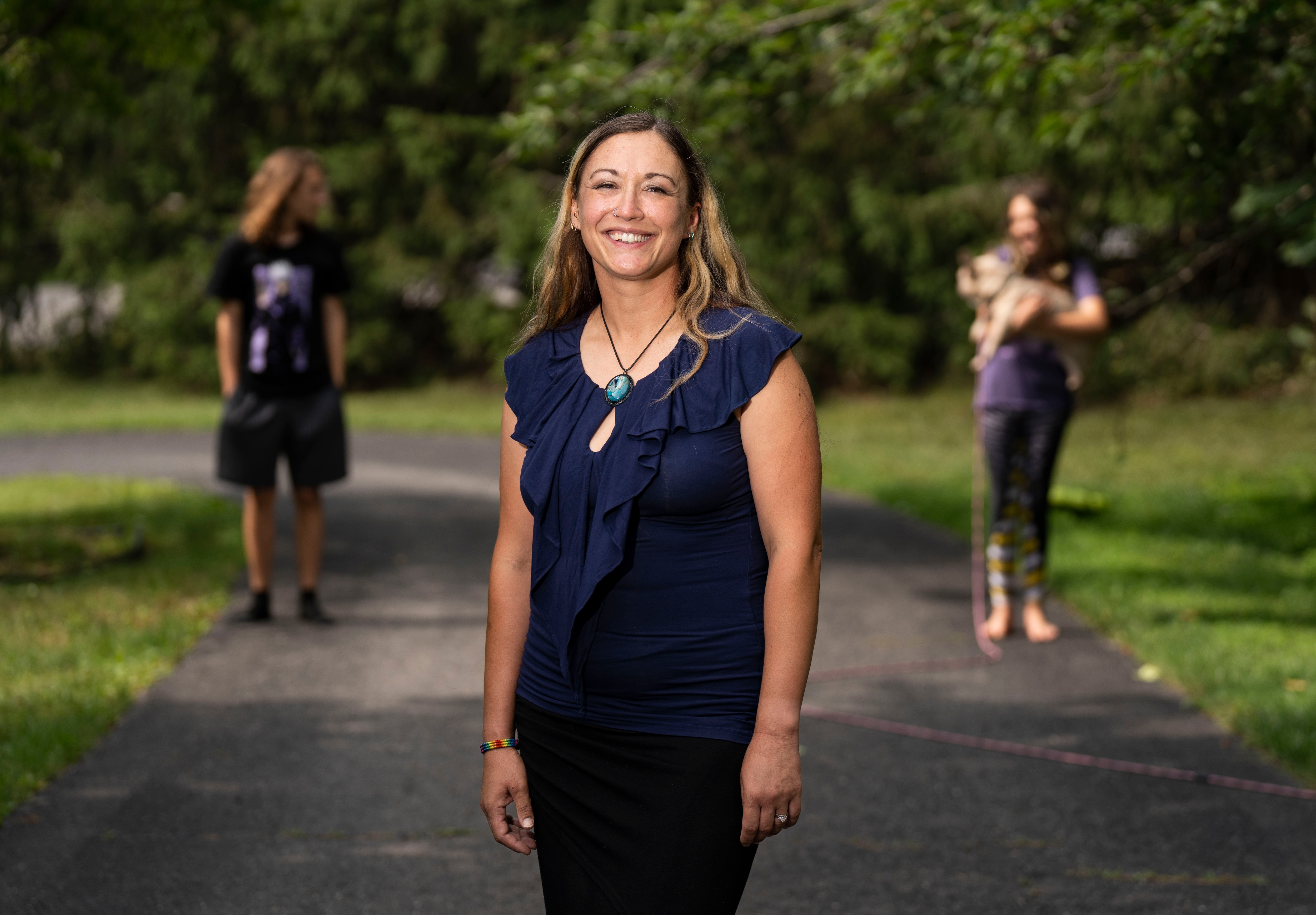 Carolyn Barth poses for a portrait in her yard with her children behind her in Ellicott City on Wednesday June 28, 2023.