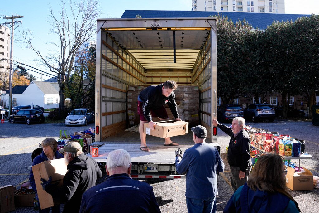 Joe McMillan, center, unloads turkeys from a delivery truck during a Thanksgiving holiday meal giveaway at Trinity Episcopal Church in Towson, Md., on Monday, November 24, 2025. The Assistance Center of Towson Churches organized the event, which was also held in 2024.