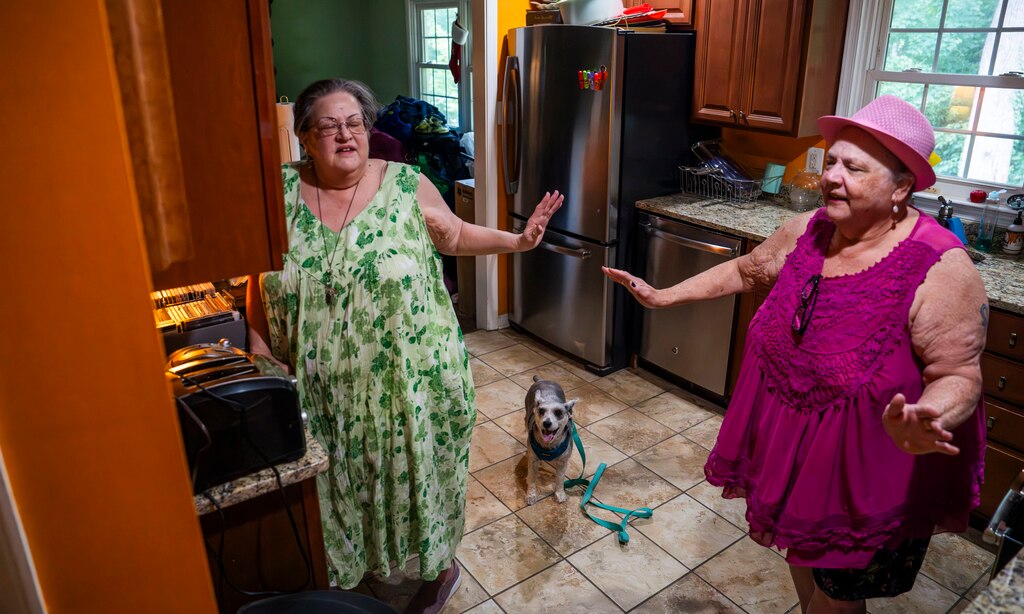 The Kalinich sisters dance to music together in their kitchen on July 17, 2024.