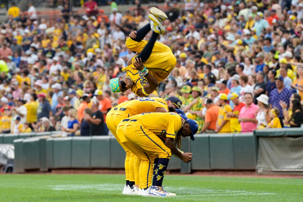 Savannah Bananas first base coach and choreographer Maceo Harrison flips over four teammates during a Banana Ball game against The Firefighters at Oriole Park at Camden Yards in Baltimore, Md. on Friday, August 1, 2025. It’s the first of two games to be played at Camden Yards this weekend.