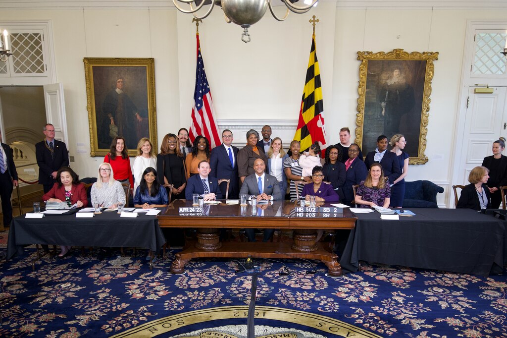 Lawmakers, advocates, DHS officials, and welfare theft victims gather for a bill signing in April 2023.