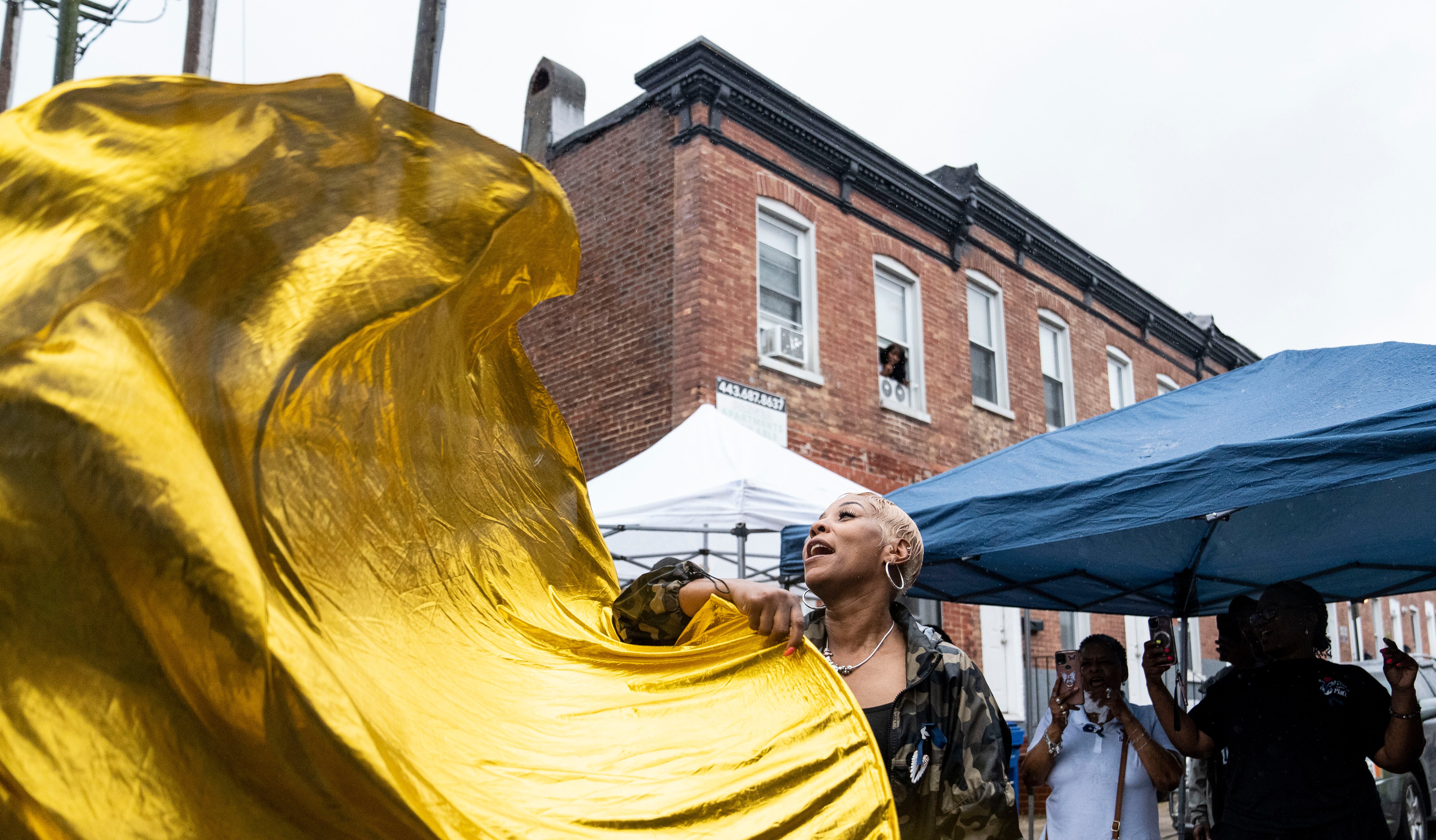 Donna Bruce waves her praise flags through the newly renamed street, Devon Wellington’s Way after the ceremonial street signing, in Baltimore, June 5, 2024.