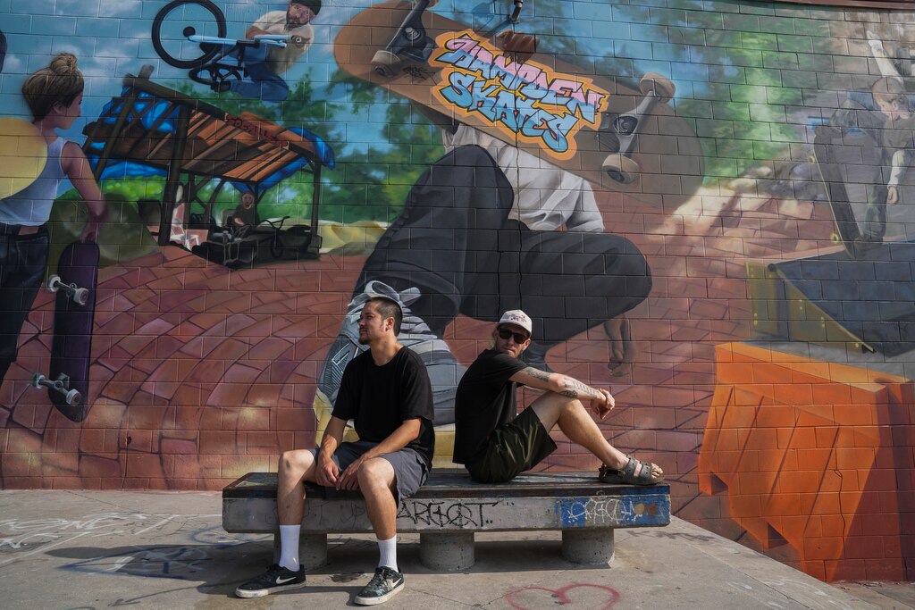 Hiro Hubbard, left, and Justin Nether sit in front of their collaborative mural at Skatepark of Baltimore in Hampden. Baltimore City, Md. on July 11, 2025.