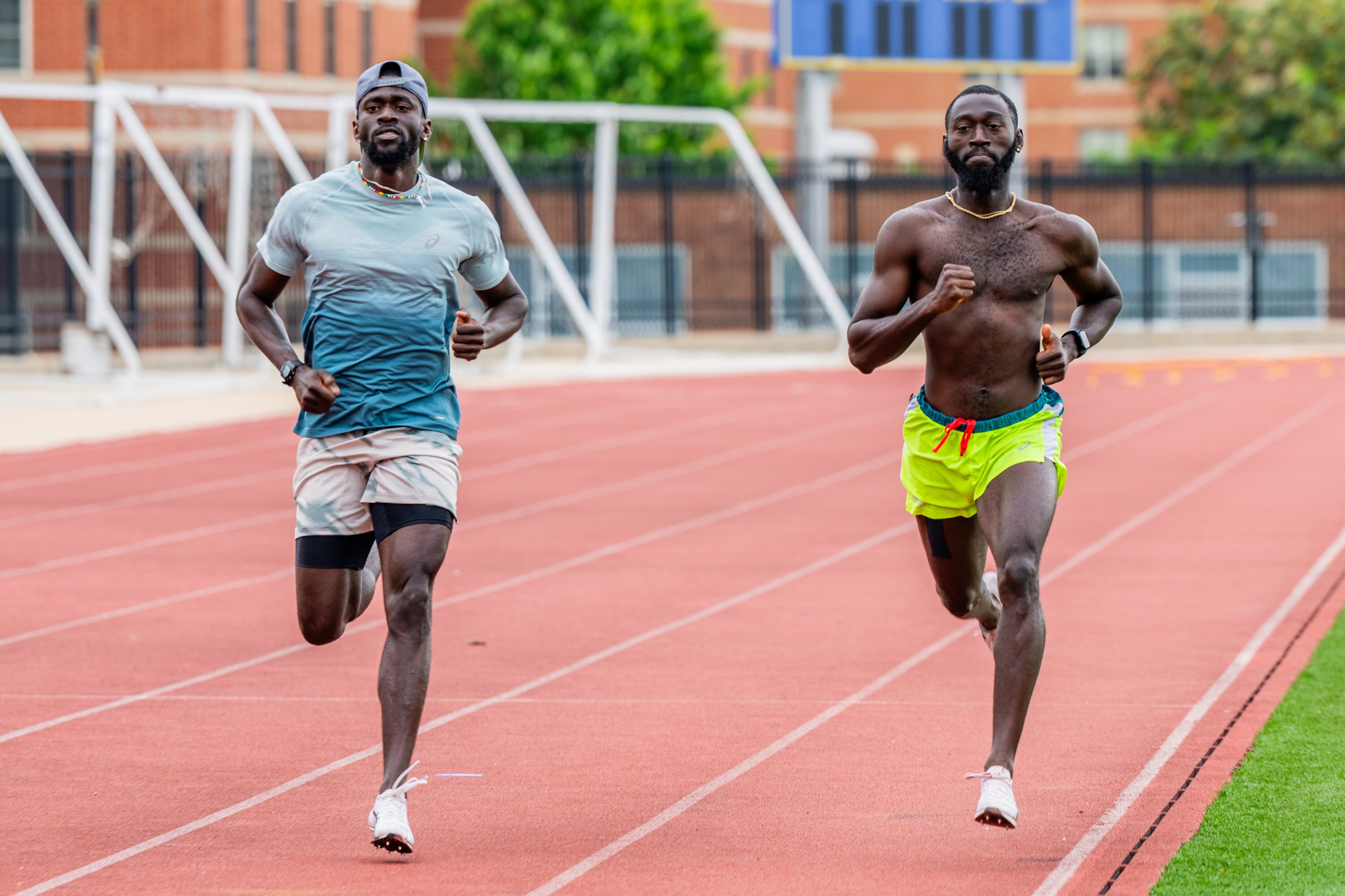 Coppin State University alumni Joseph Amoah (left) and Martin Owusu-Antwi run 200 meters as part of their speed endurance training to qualify for the Olympics at the school’s track.