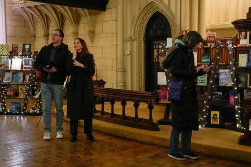 Mike Gannon, left, admires the church interior standing Ashley Kneale during the Ivy Bookshop’s pop-up event inside the Mount Vernon Place United Methodist Church and Asbury House in Baltimore, Md. on Thursday, December 4, 2025.